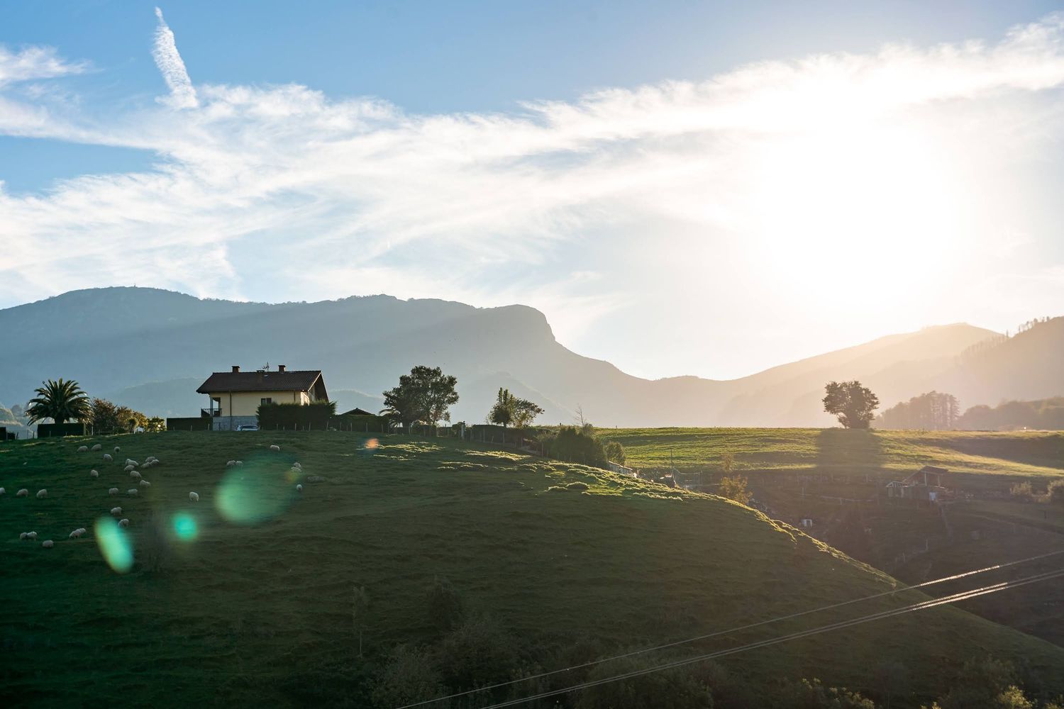 Panoramic view of misty mountains and valleys at sunset with dramatic cloud formations.