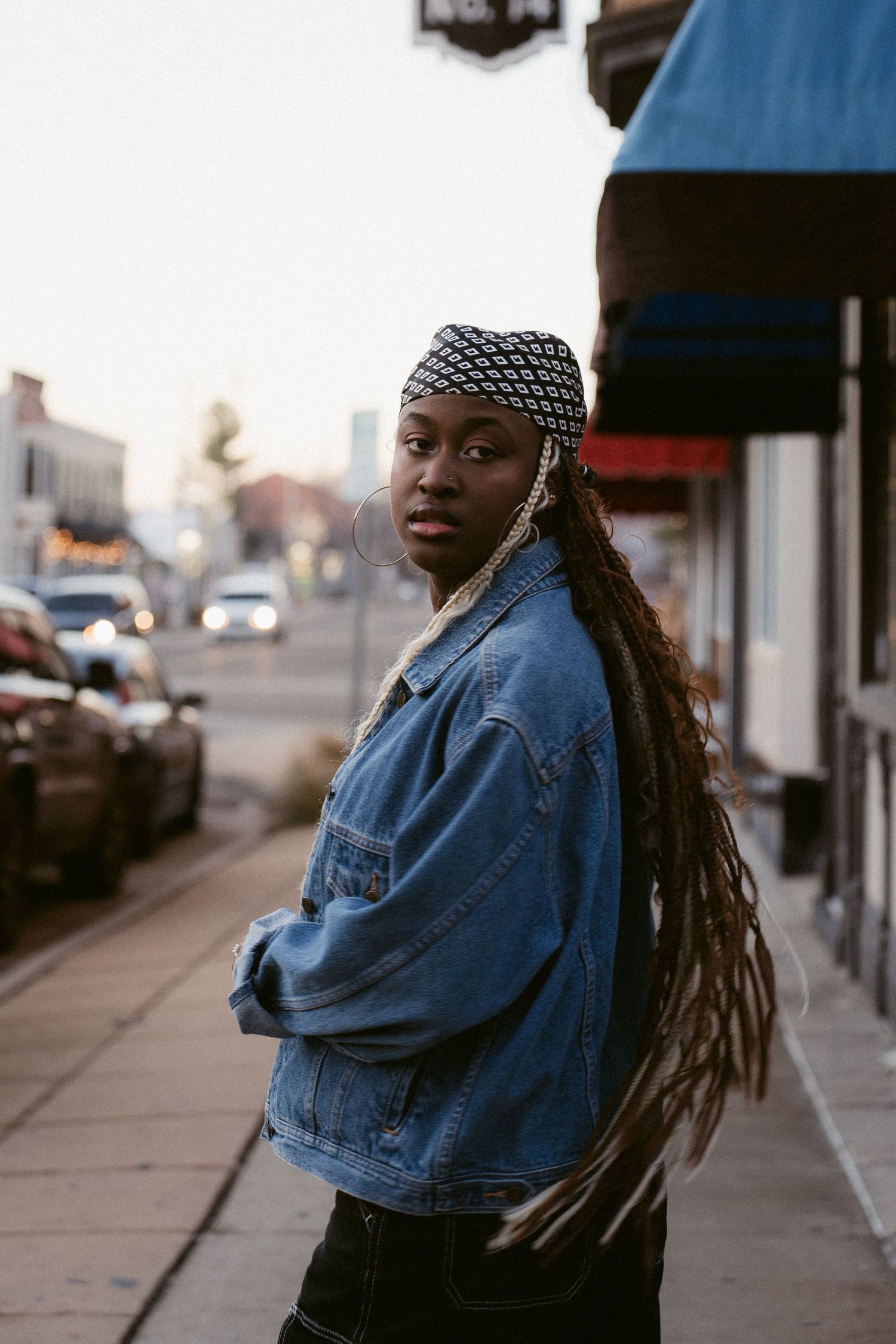 Portrait image of a woman walking on the sidewalk looking back at the camera