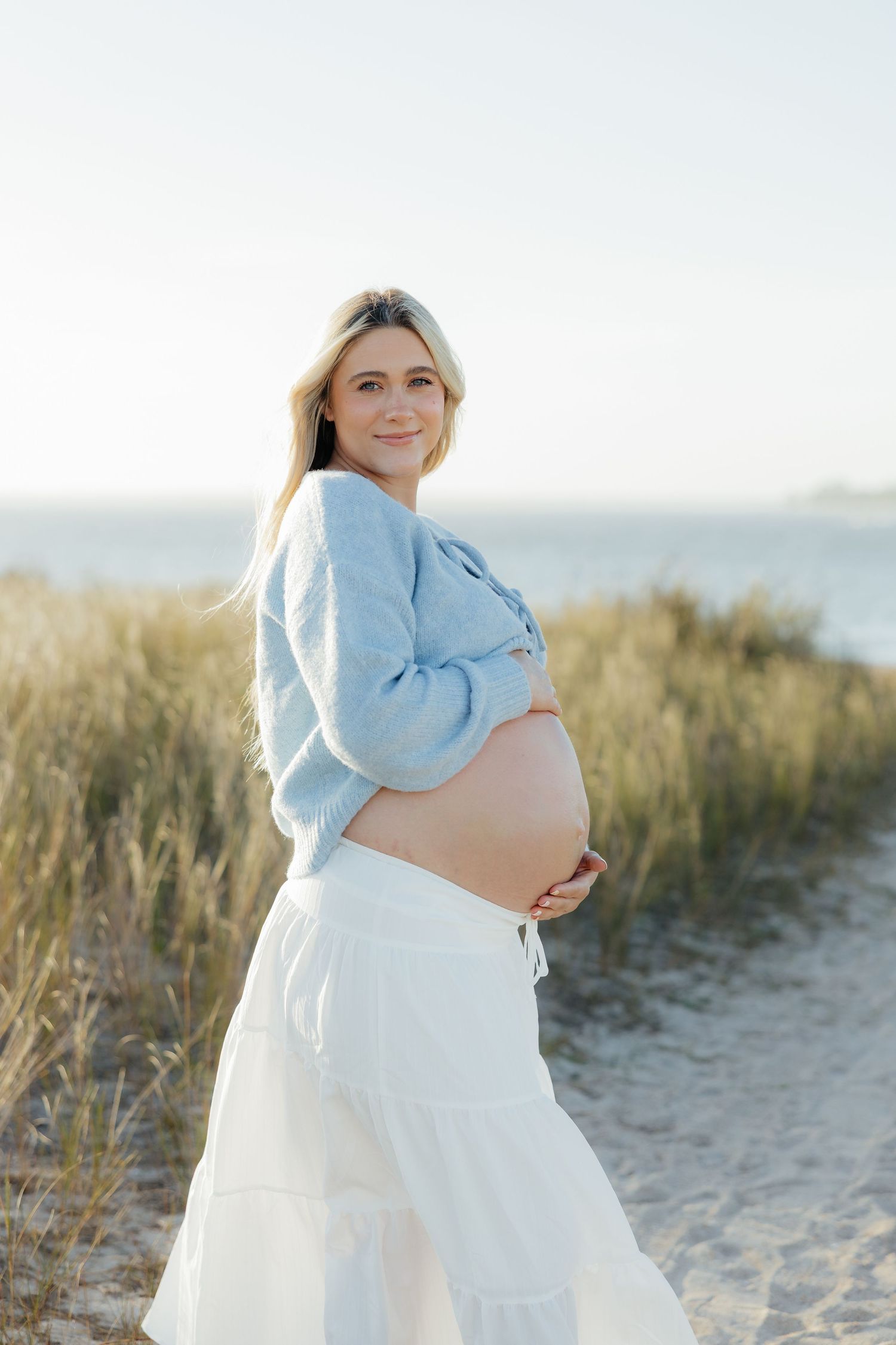 Maternity Photography session of expecting mother on a beach with tall grass at Fort Clinch State Park.