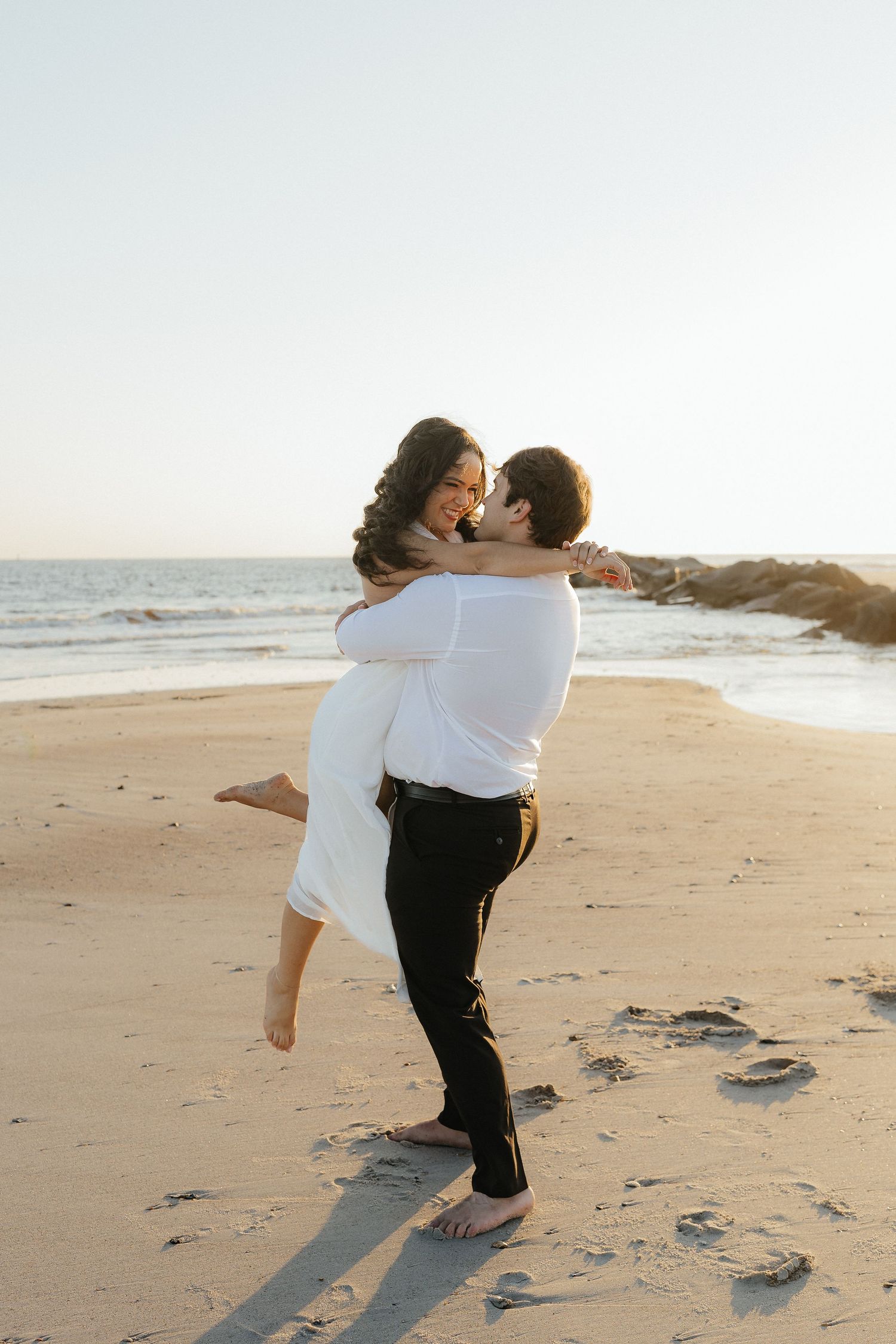 Romantic couple dancing and embracing on a serene beach during sunrise hour at Fort Clinch State Park.