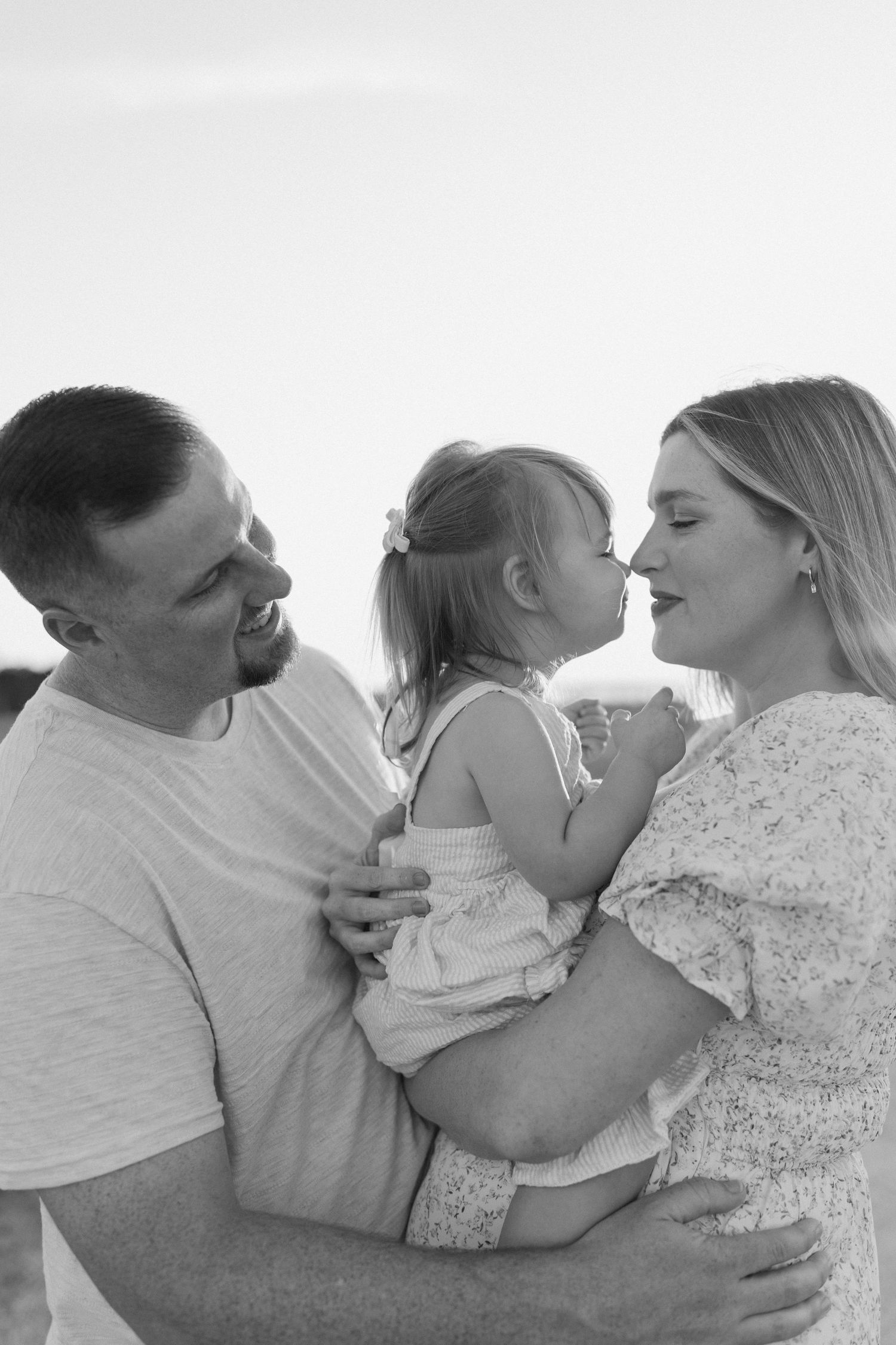 Sweet family moment captured in black and white as they embrace and share loving kisses in Fort Clinch State Park.