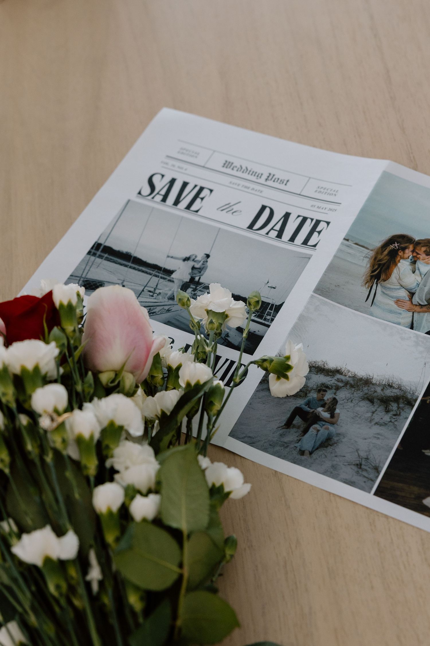 A save-the-date card with engagement photos displayed next to fresh flowers.