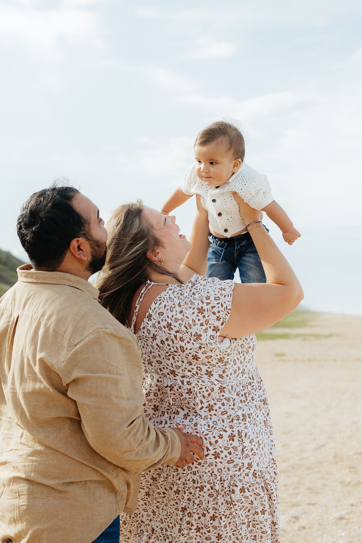 Happy family enjoying a tender moment together at the beach on a sunny day.