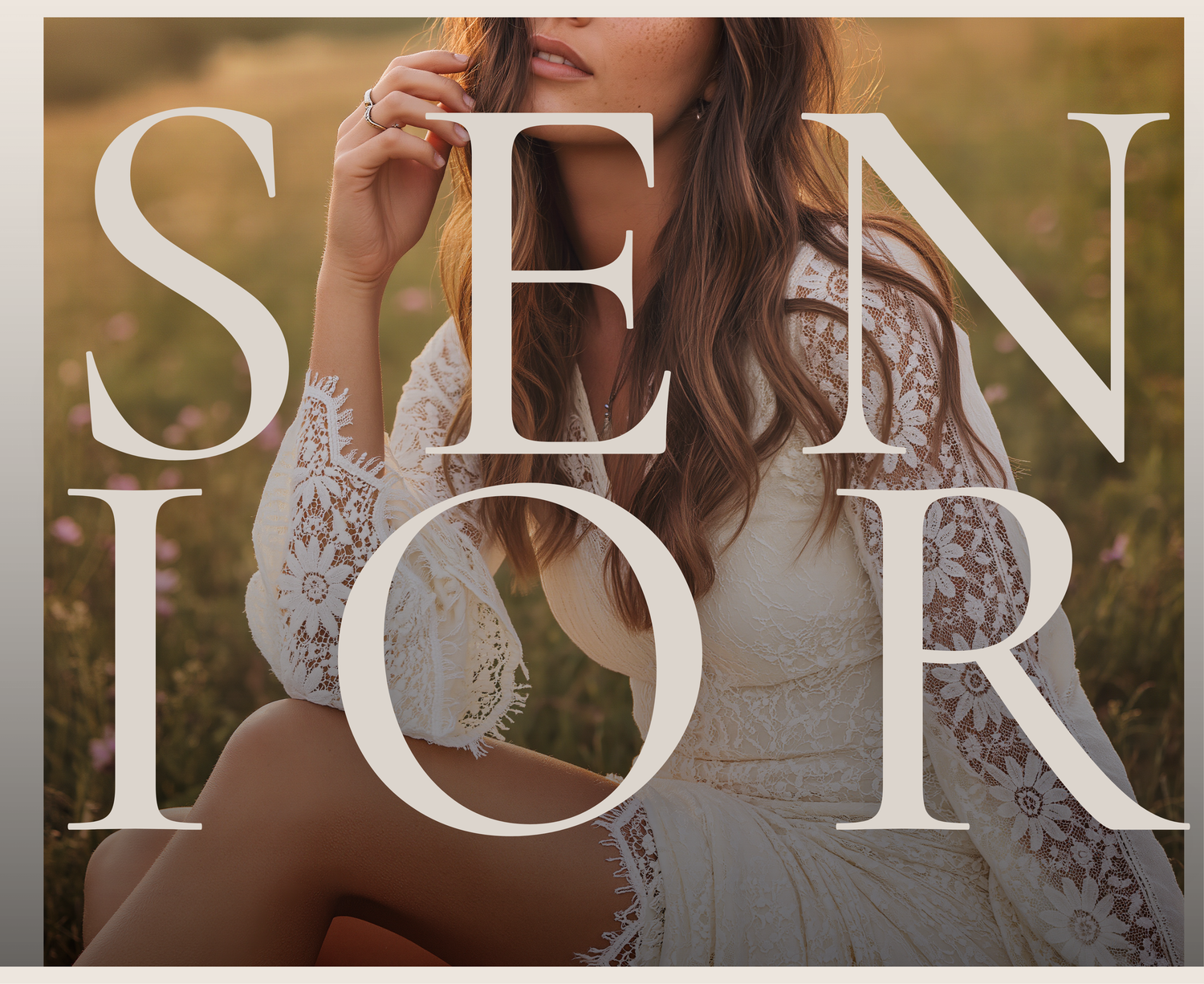 Young woman in white lace dress sitting in a golden field, overlaid with bold SENIOR text for senior portrait photography.