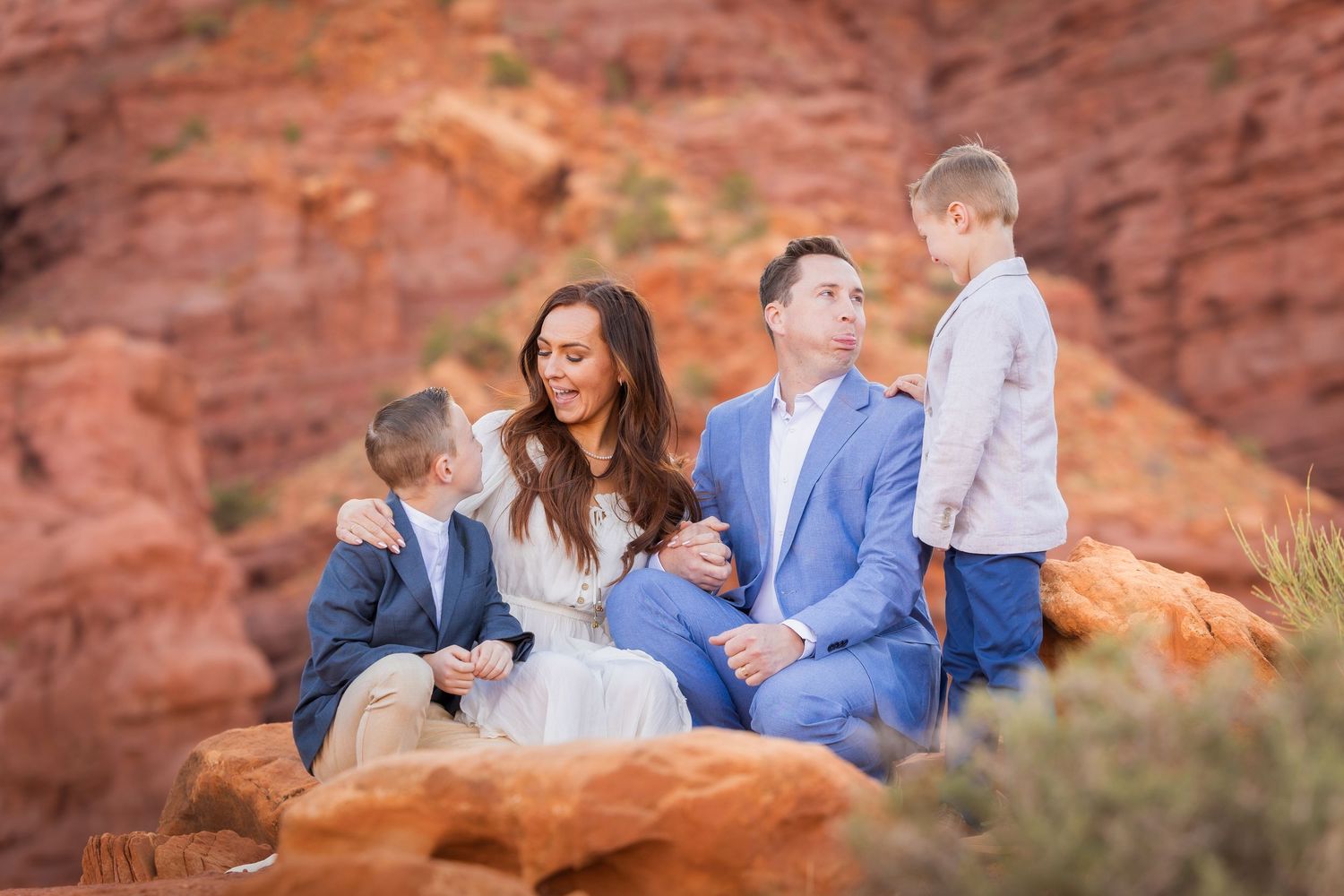 A playful family photoshoot among the desert landscape and red rocks.
