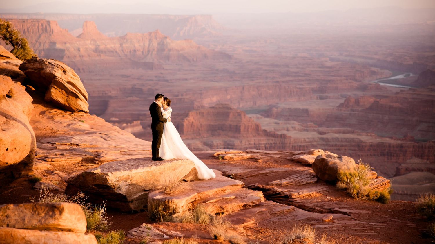 A scenic panoramic view of the red rock formations and deep canyons in Canyonlands National Park at sunset.