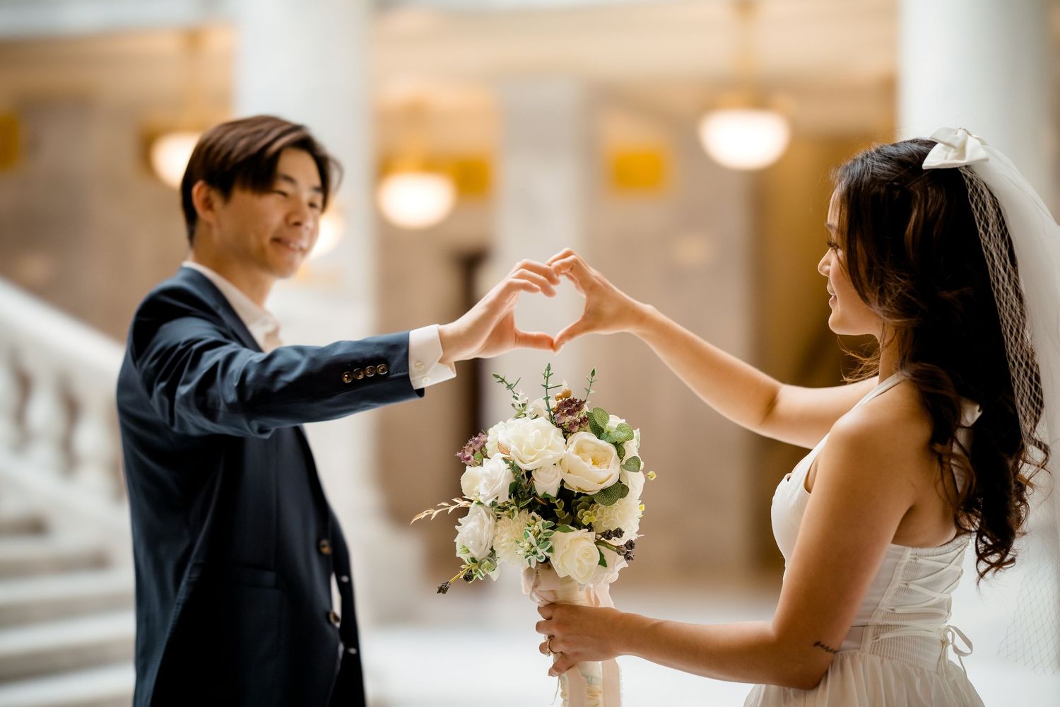 A couple dancing together in an elegant indoor venue with soft lighting.