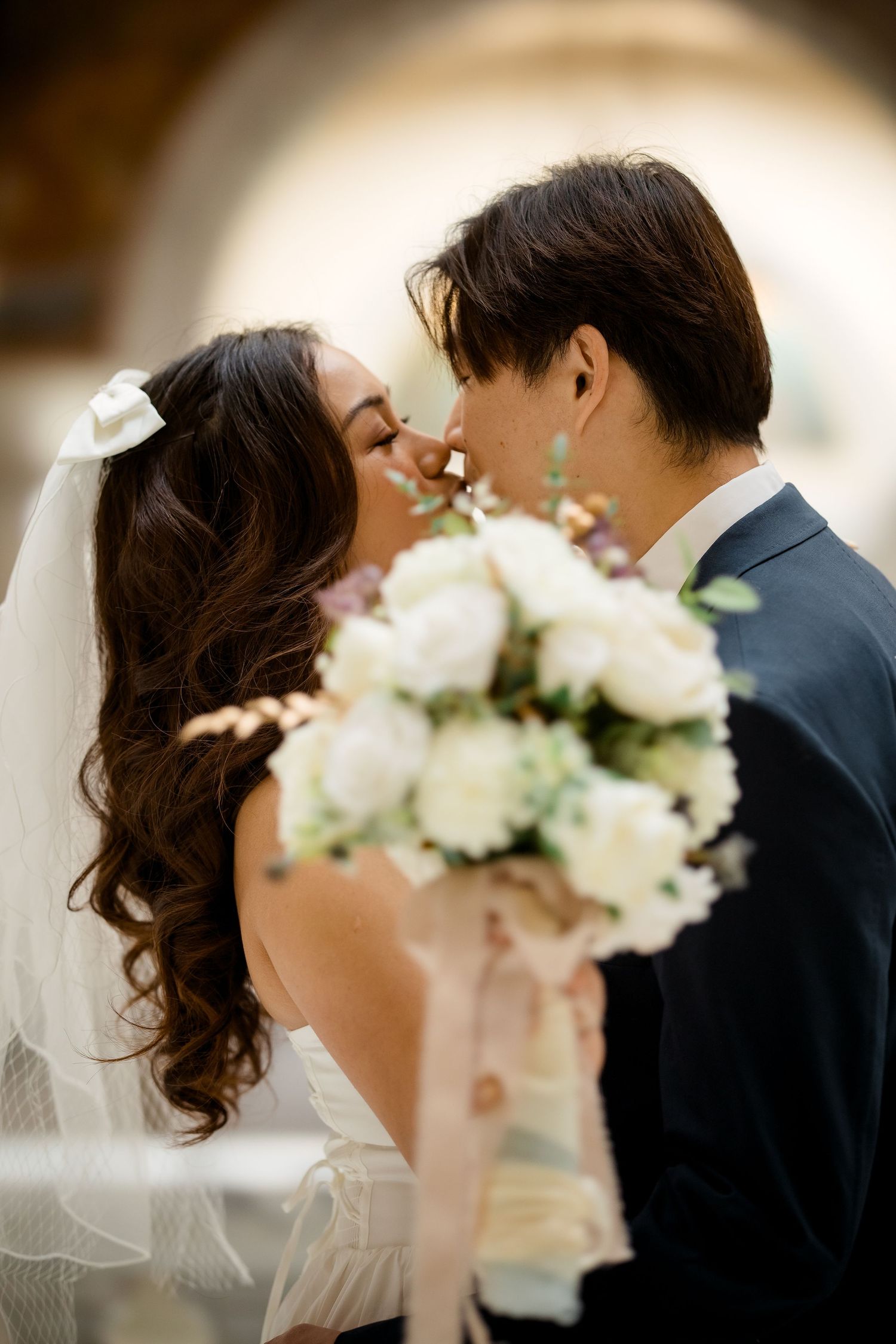 Close-up wedding photos featuring a white floral bouquet and romantic moments.