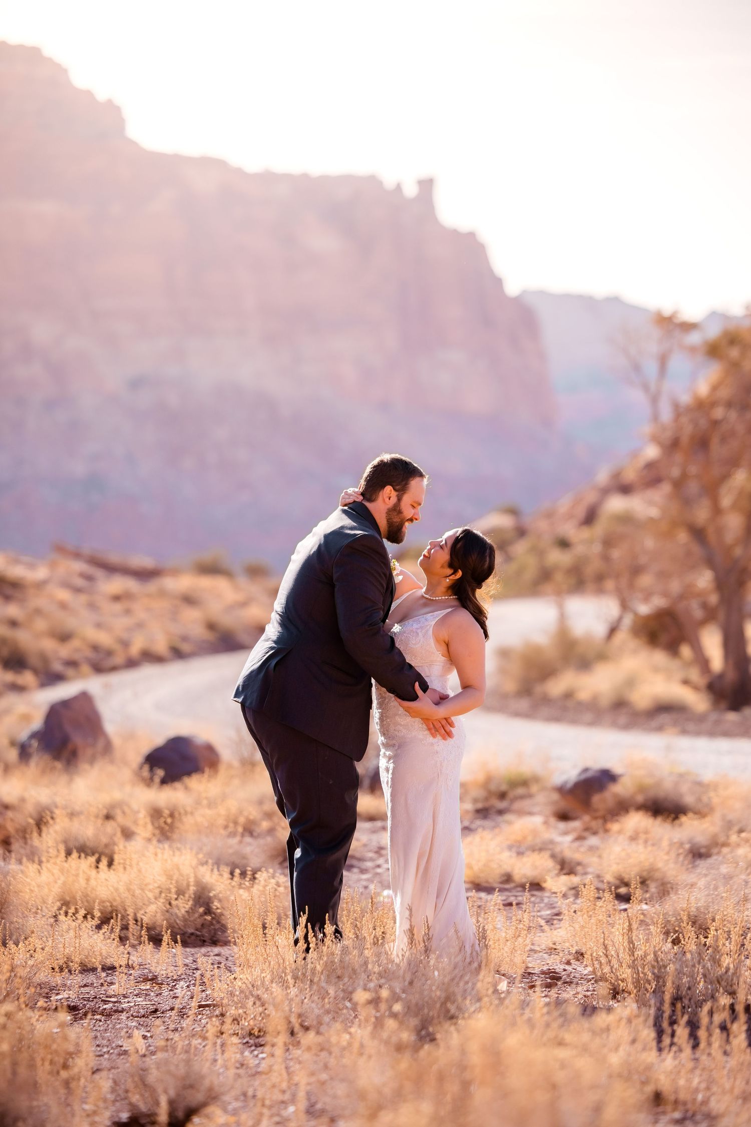 A romantic desert wedding photoshoot with mountains and golden light.
