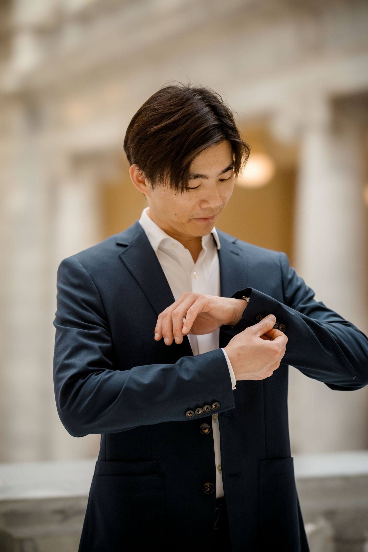 A series of photos showing a groom in a dark suit adjusting his tie.