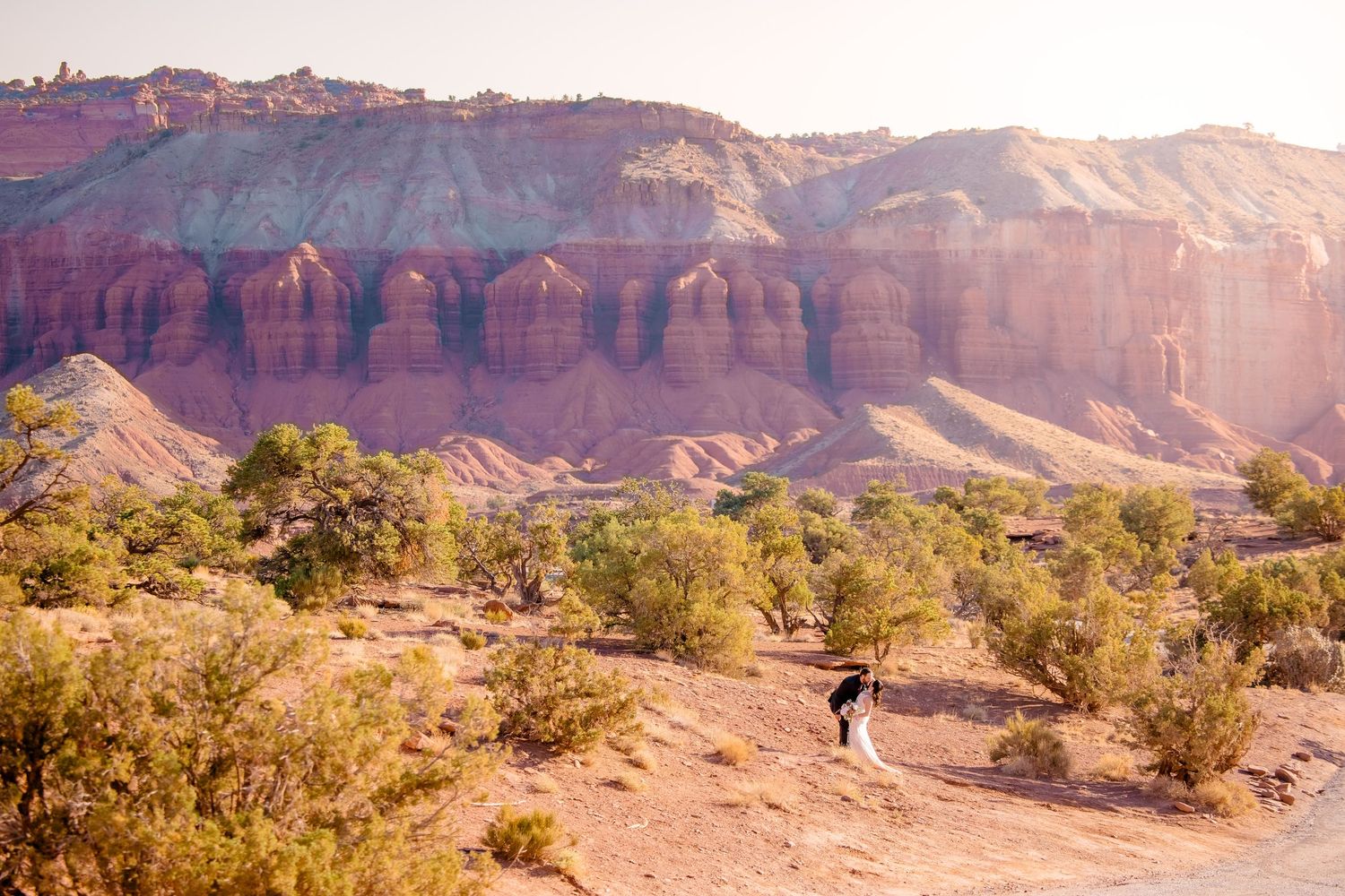 Panoramic view of red rock formations and desert landscape in Utah's scenic canyon country at sunset.