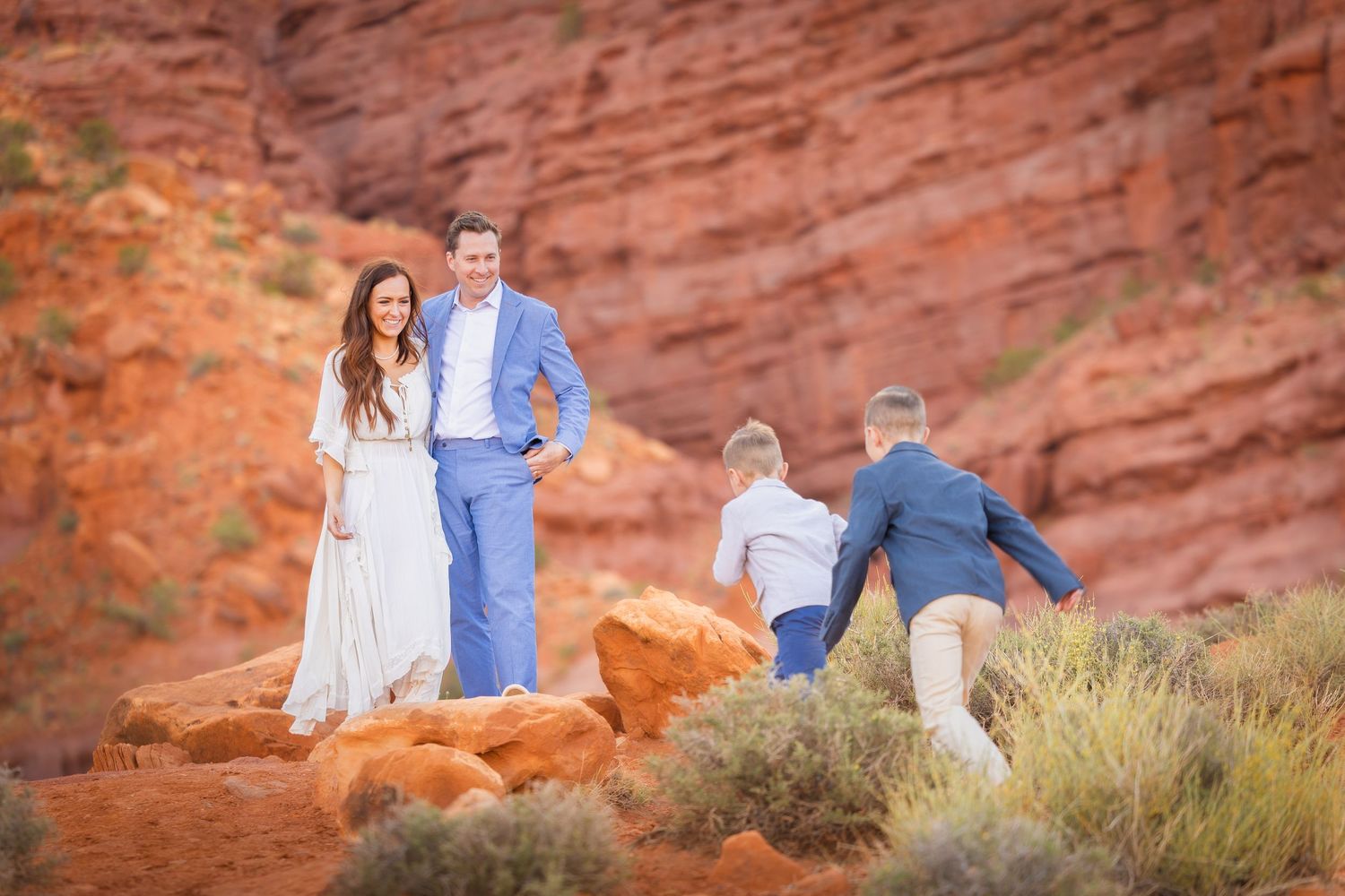 A candid family moment captured against stunning red rock cliffs.
