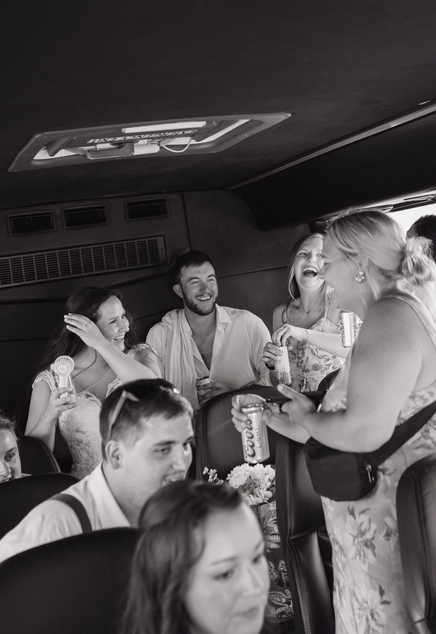 Wedding party celebrating and drinking together in a party bus or limousine.