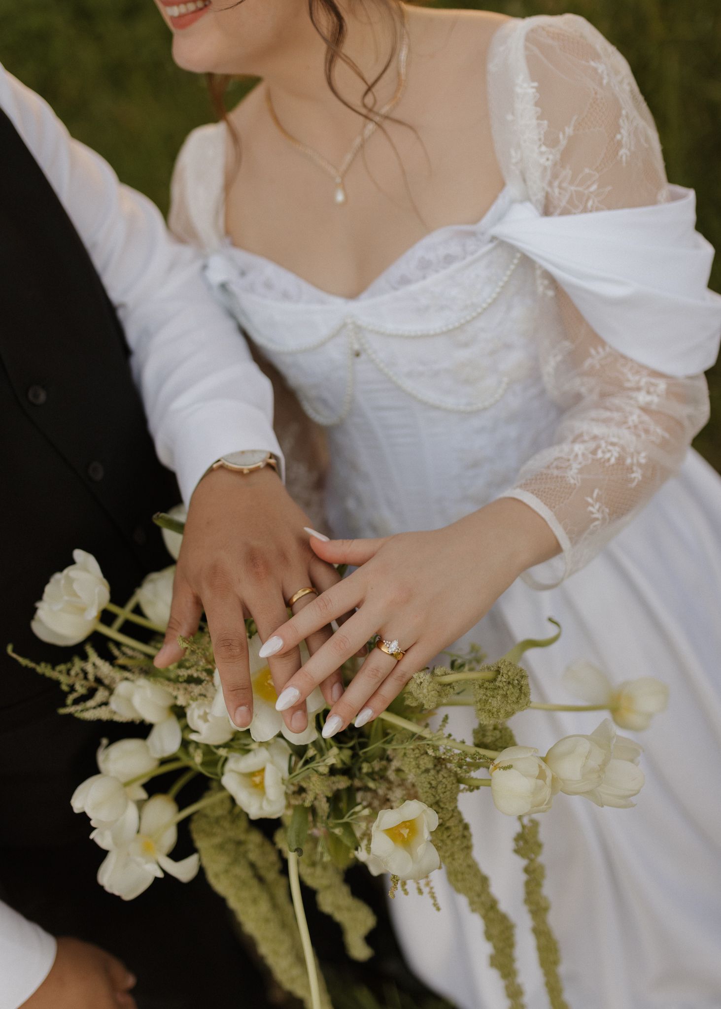 Close-up of delicate white wedding flowers and lace details.