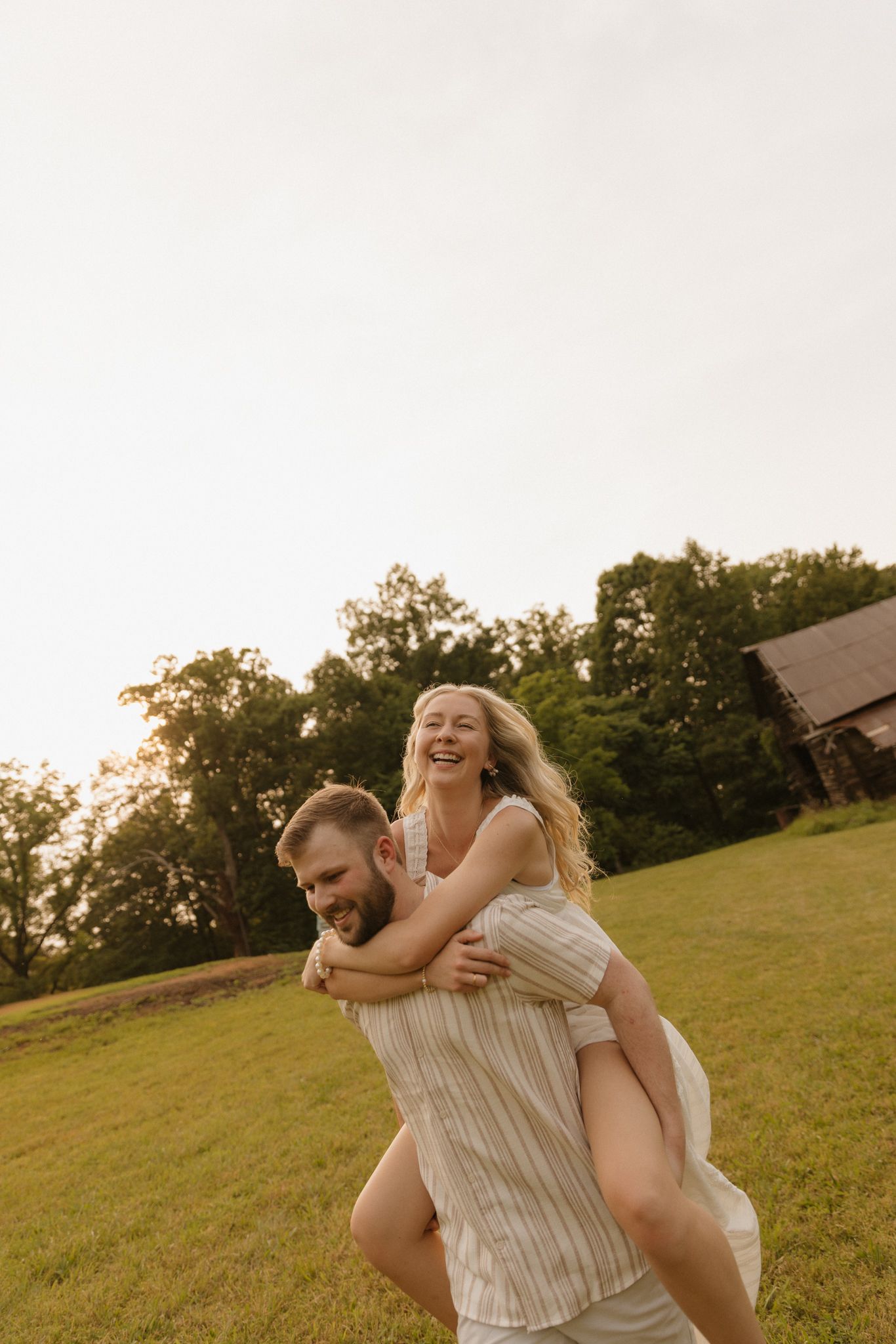 A playful summer moment captured on a grassy hillside with golden sunlight.