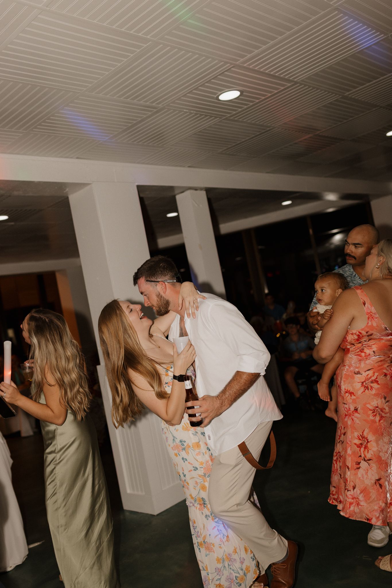 Dance party scene with colored lights reflecting on textured ceiling.
