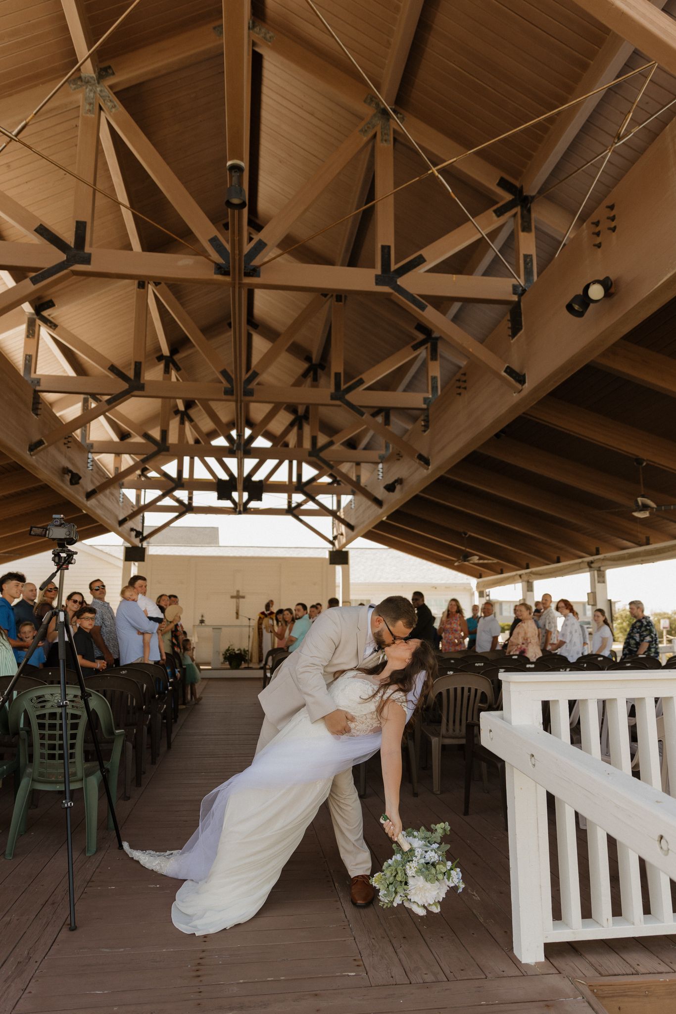 Romantic wedding dance scene in a rustic wooden pavilion with exposed beam ceiling.