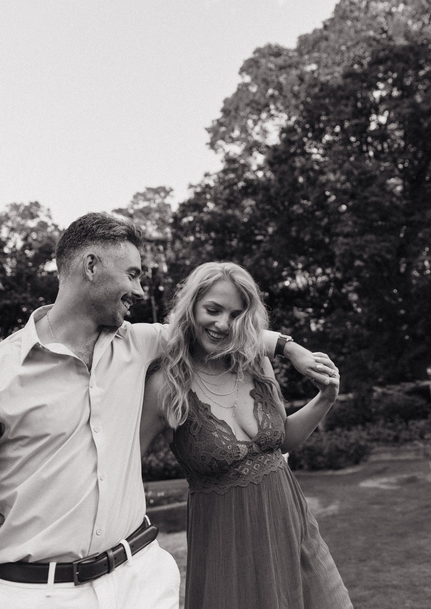 Couple laughing together during outdoor photoshoot in black and white.