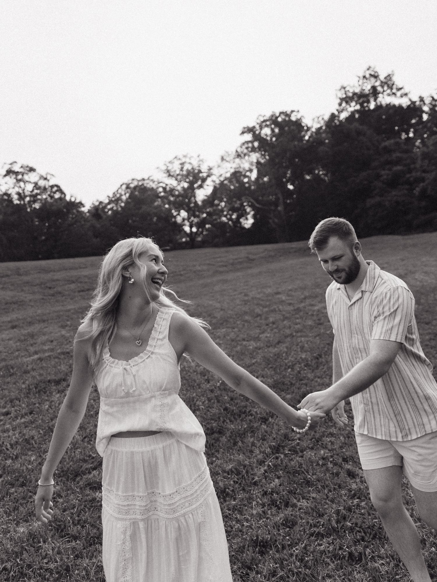 A candid black and white photo capturing a carefree dance moment outdoors.