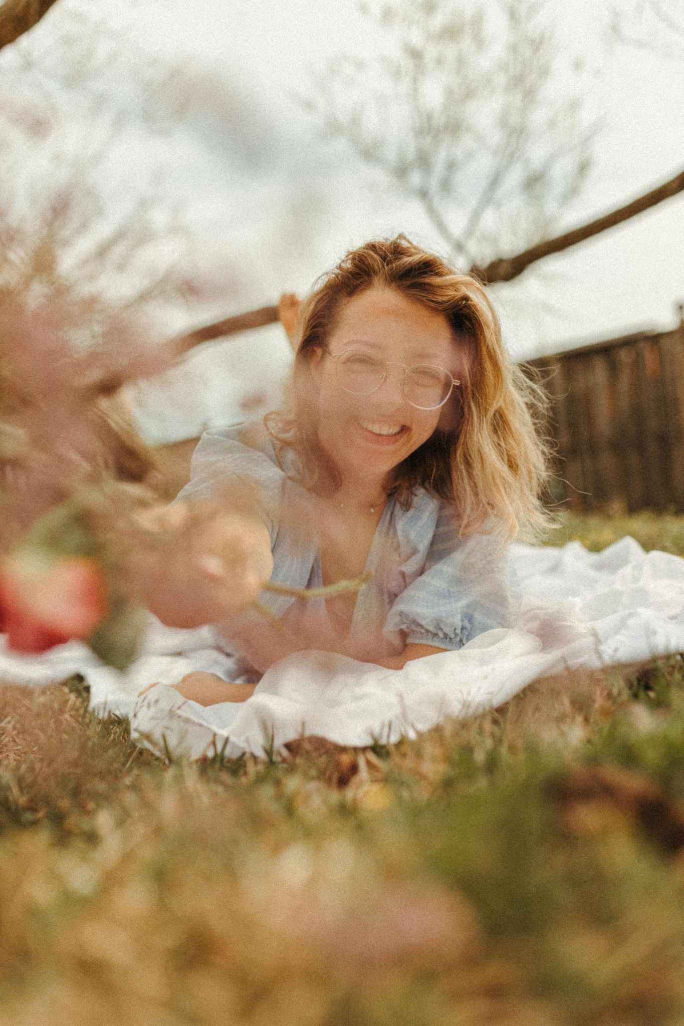 A dreamy portrait shot through flowers with soft natural lighting.