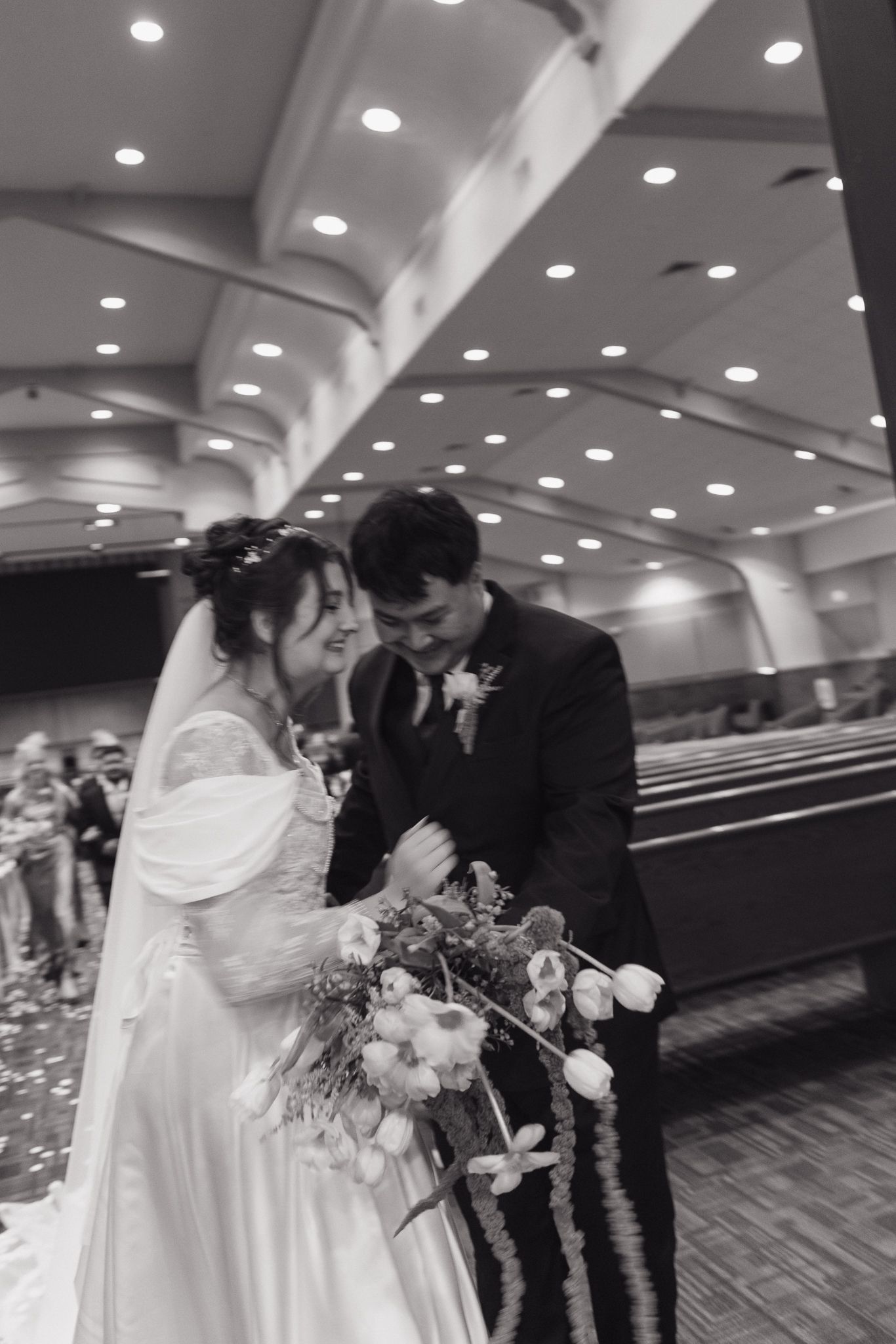 Elegant wedding ceremony captured in black and white in an indoor venue.