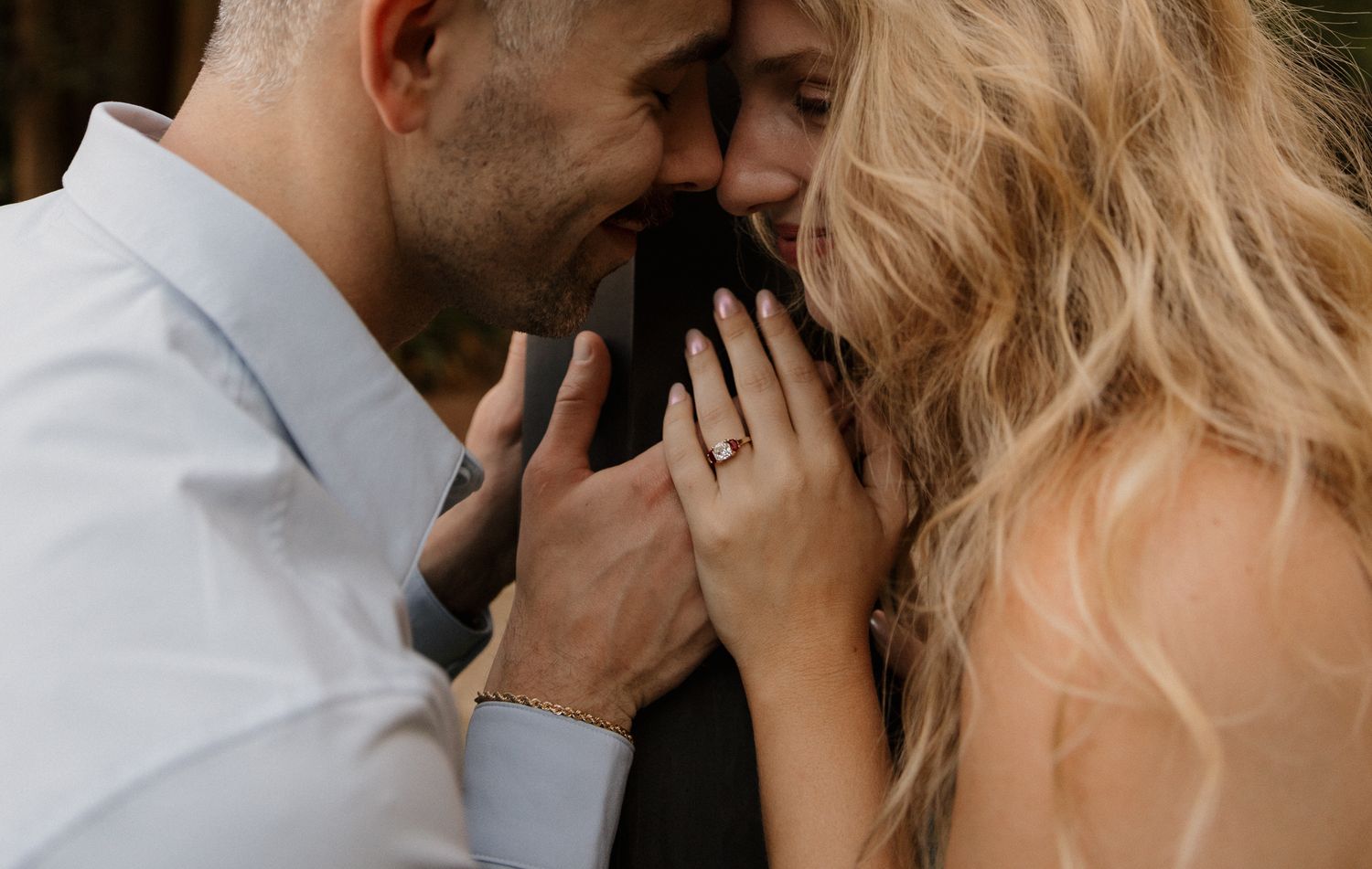 An intimate moment between a couple sharing a tender embrace in soft lighting.