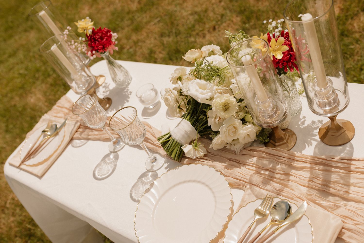Elegant wedding reception table setting with white floral centerpieces and crystal glassware.