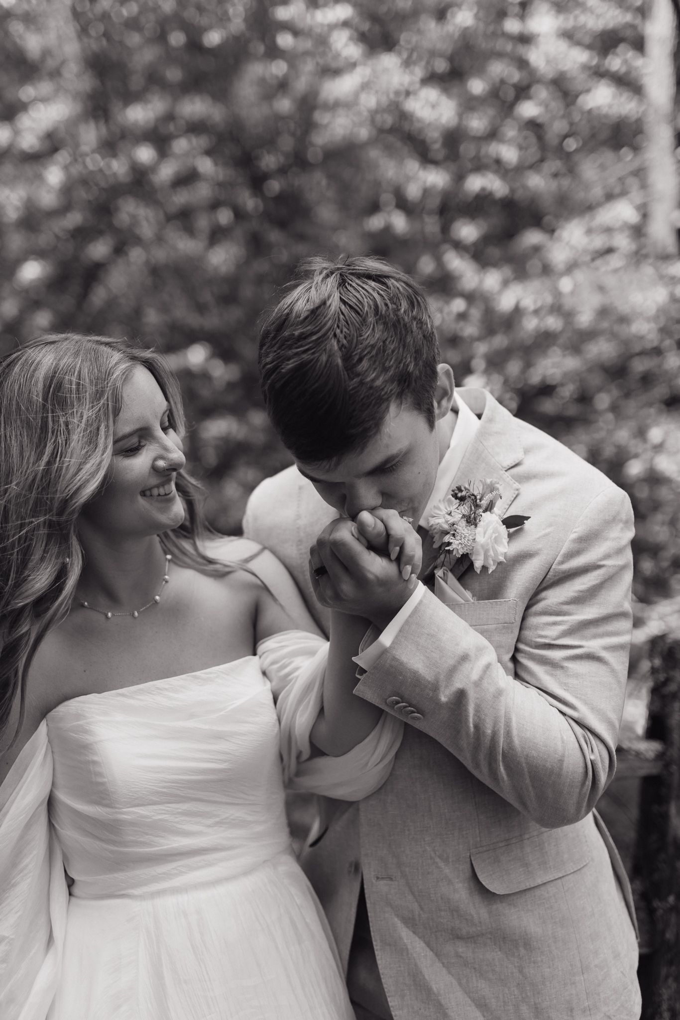 Intimate black and white portrait of a couple sharing an emotional moment in formal wedding attire.