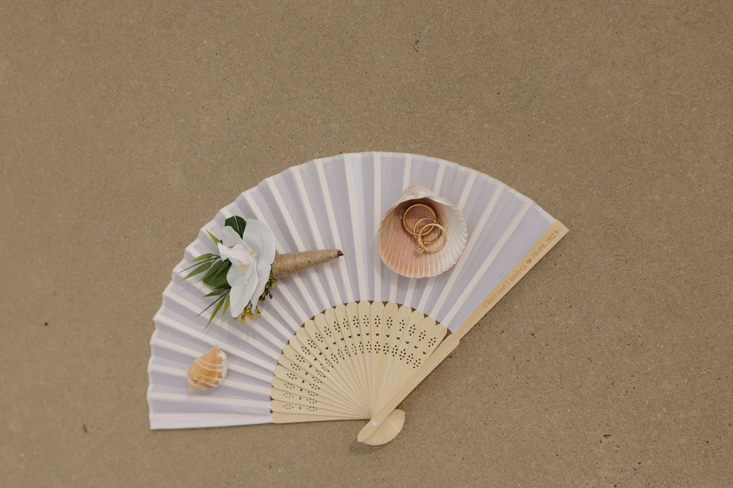 A collection of delicate white paper fans with floral designs arranged in a row on a brown textured background.