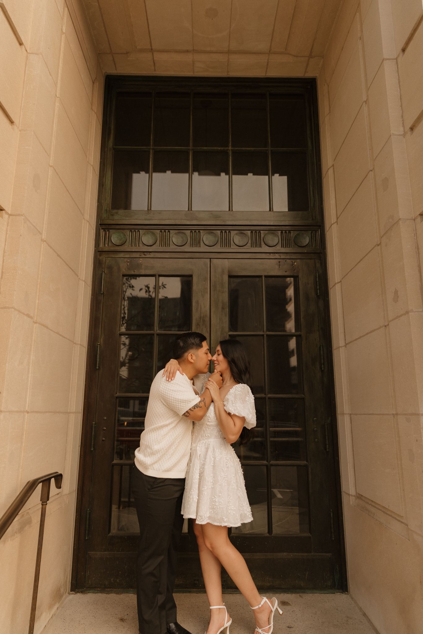 Romantic couple sharing an intimate moment in front of a vintage door with ornate details.