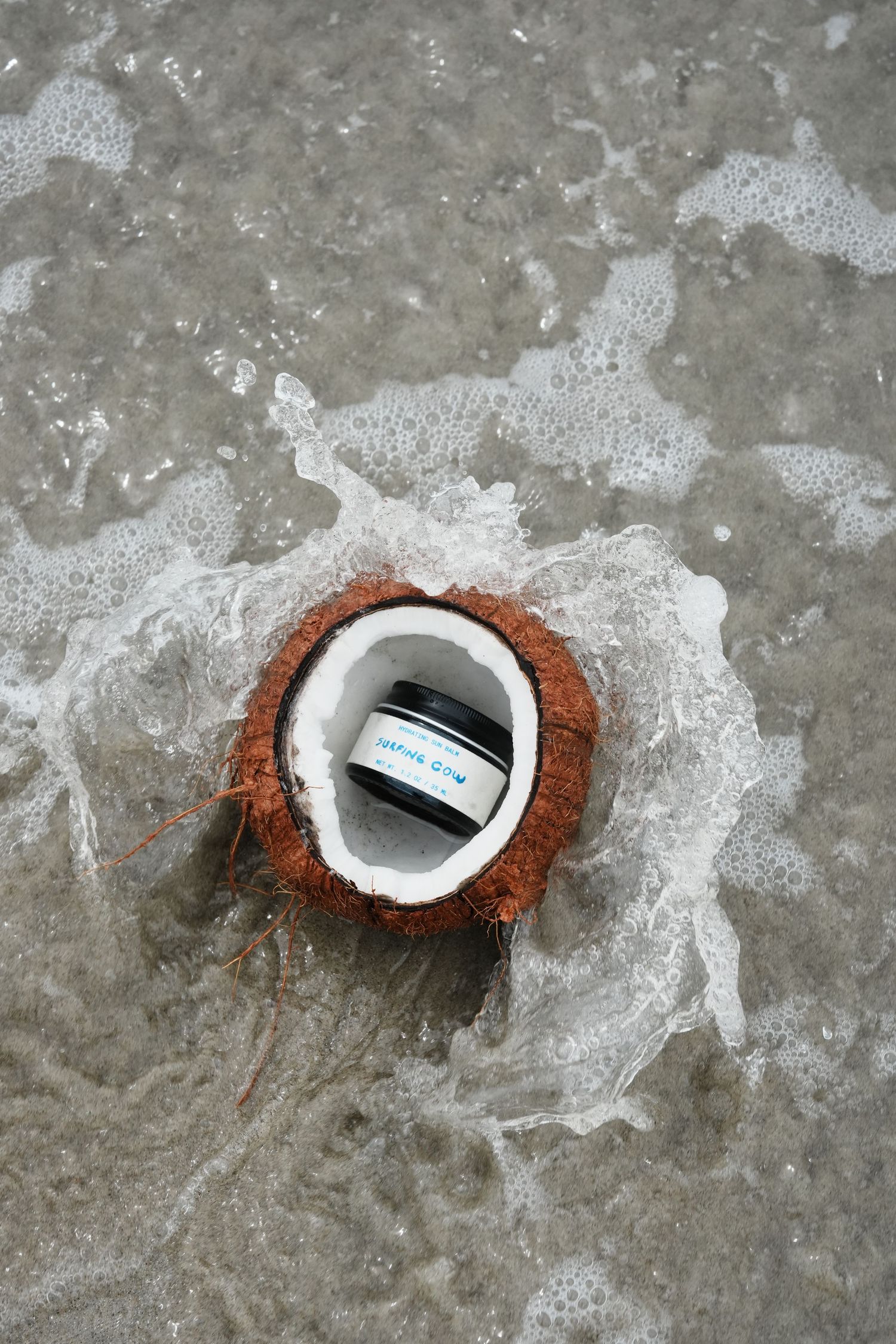 A sequence of images showing a coconut husk being broken apart to reveal a white plastic container inside.