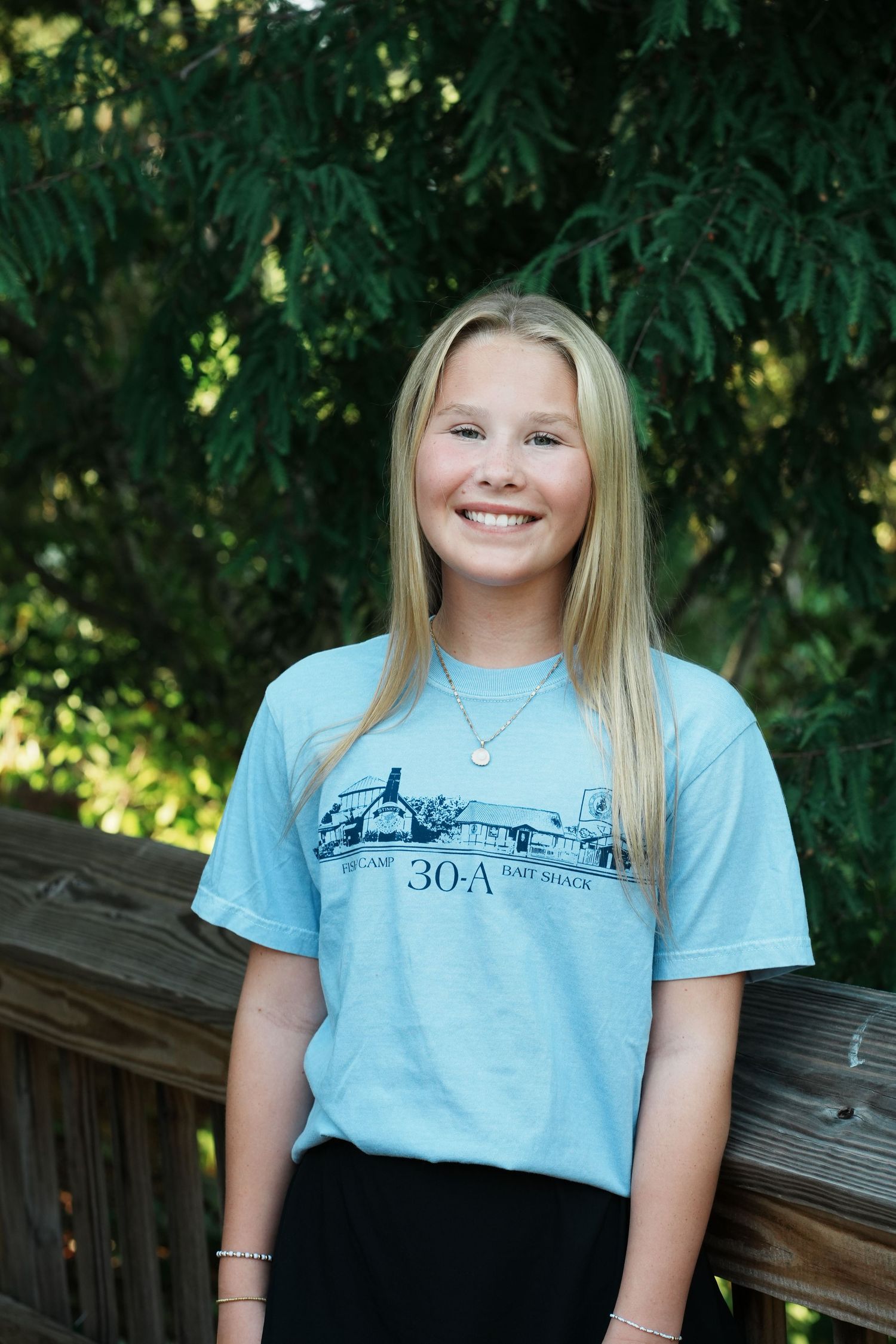 Light blue t-shirts displayed in sequence showing nautical-themed designs against a green background.