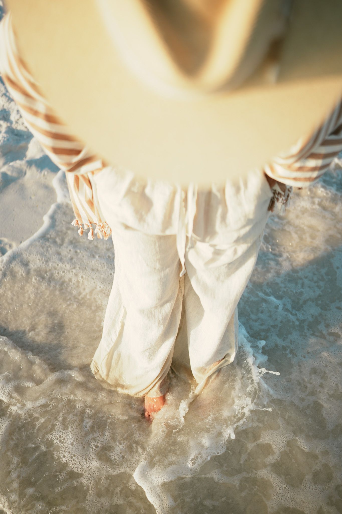 Sequence of feet splashing in ankle-deep water creating ripples and movement against concrete surface.