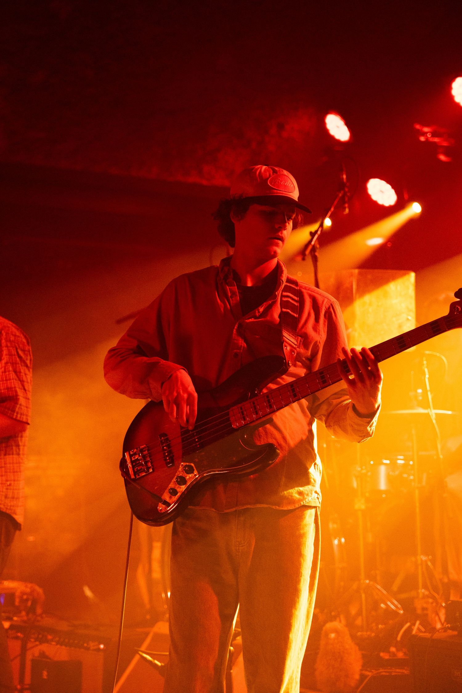 Musicians perform on stage bathed in dramatic red and orange lighting during an atmospheric concert performance.