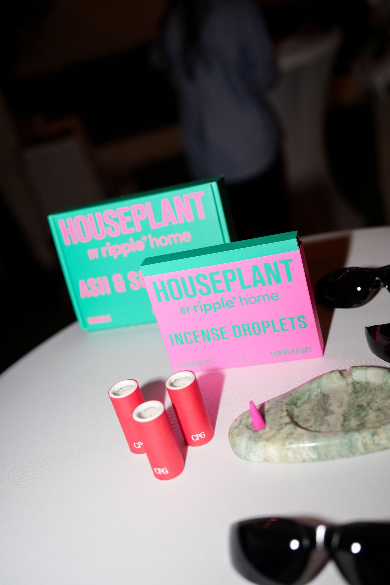 Pink and turquoise Houseplant brand packaging displayed on a white surface.