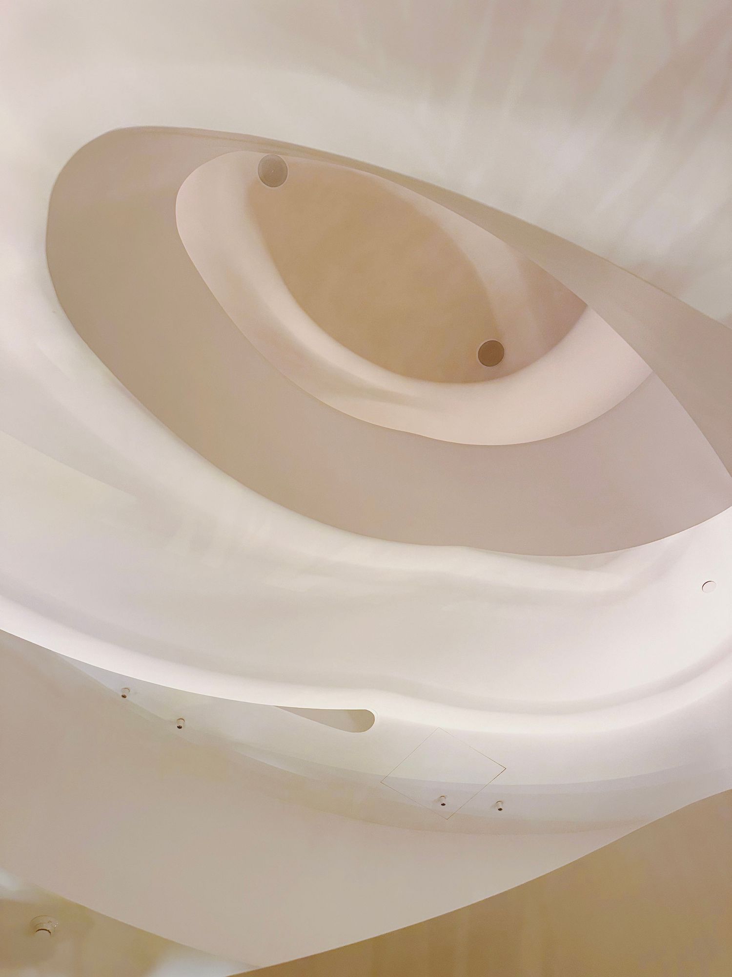An abstract architectural detail showing curved white ceiling elements in circular patterns.