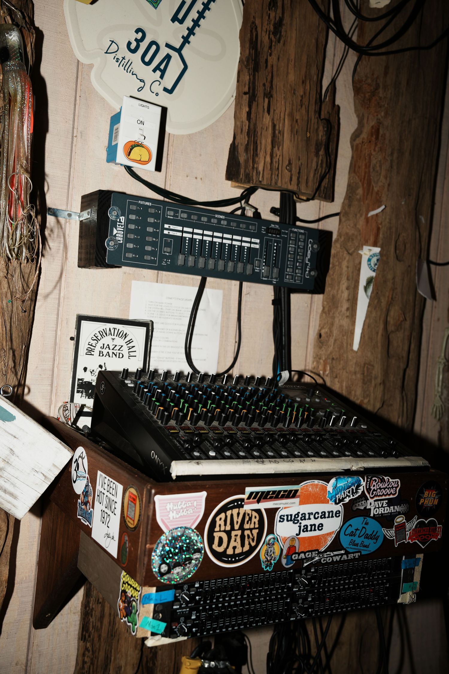 Rustic wooden wall decorated with various stickers and keyboards mounted in a dark room.