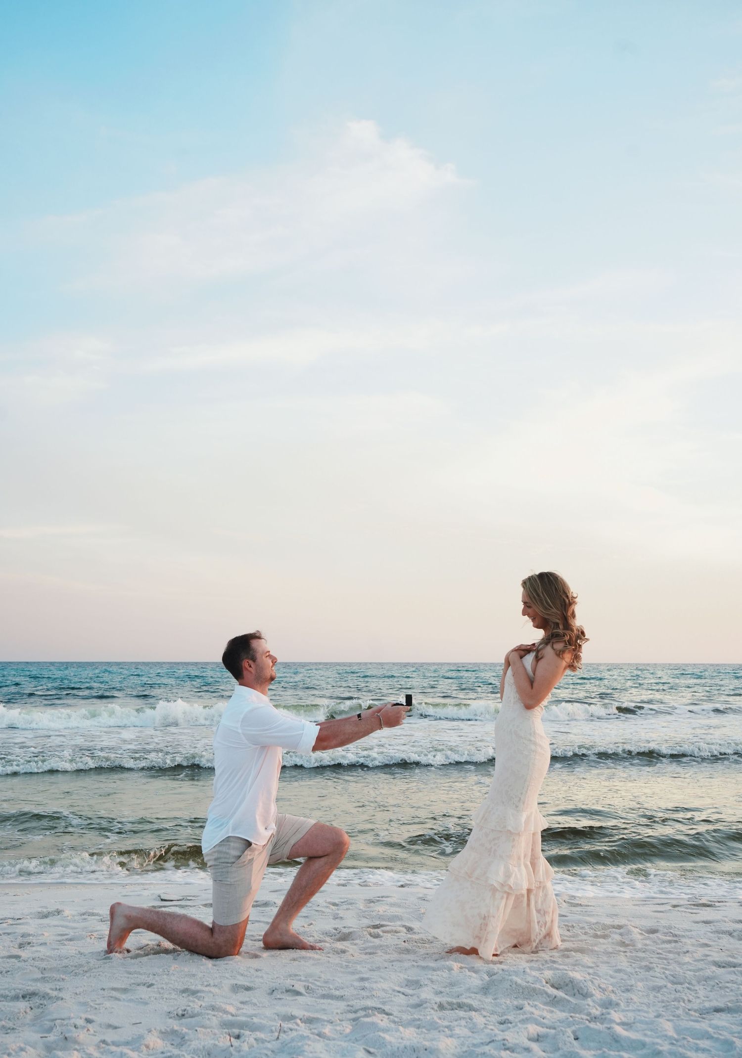 A romantic seaside proposal photoshoot sequence showing a couple on a beach during sunset by the ocean.