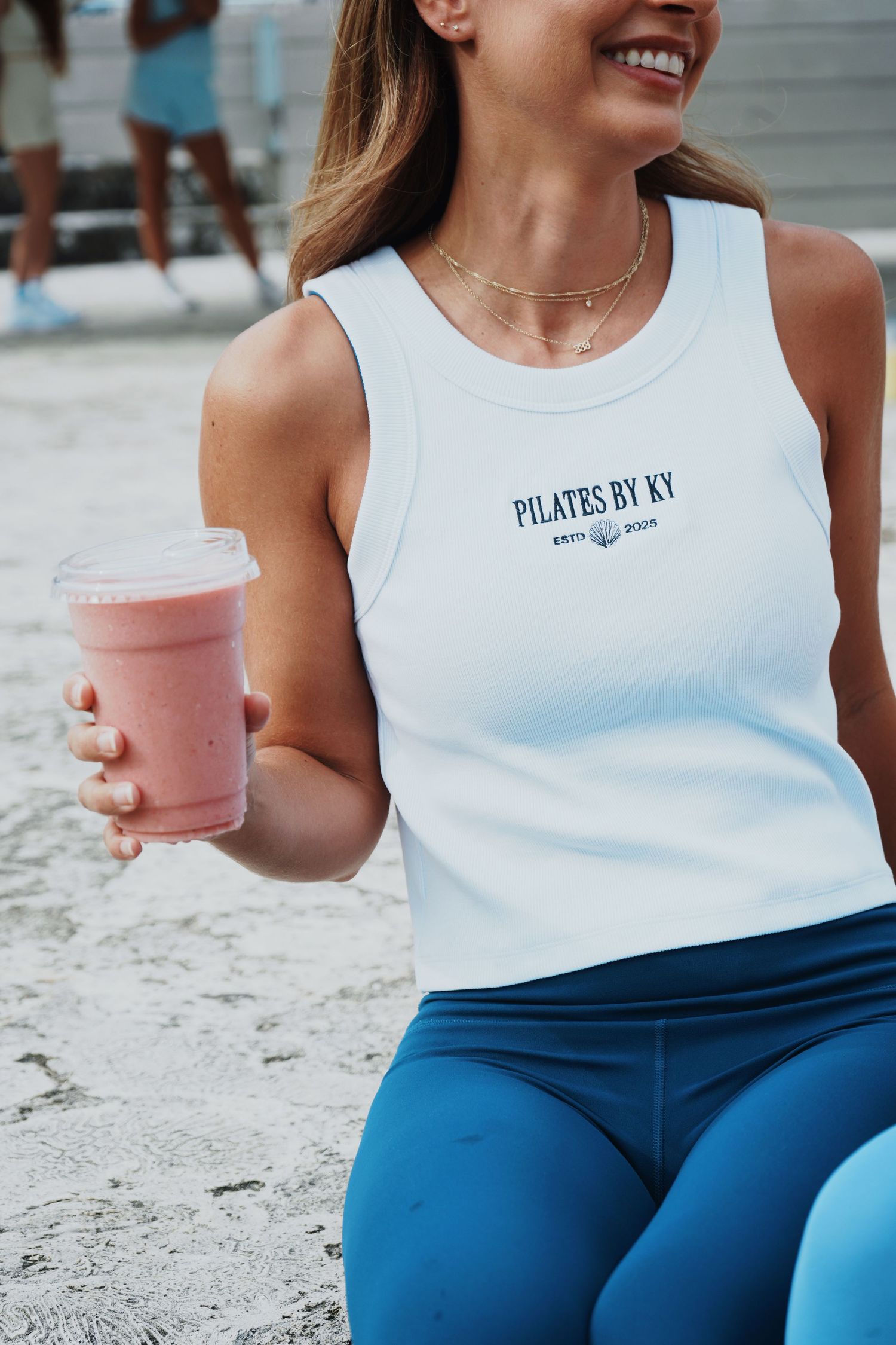 Close-up of white tank top with Pilates text worn during workout session.