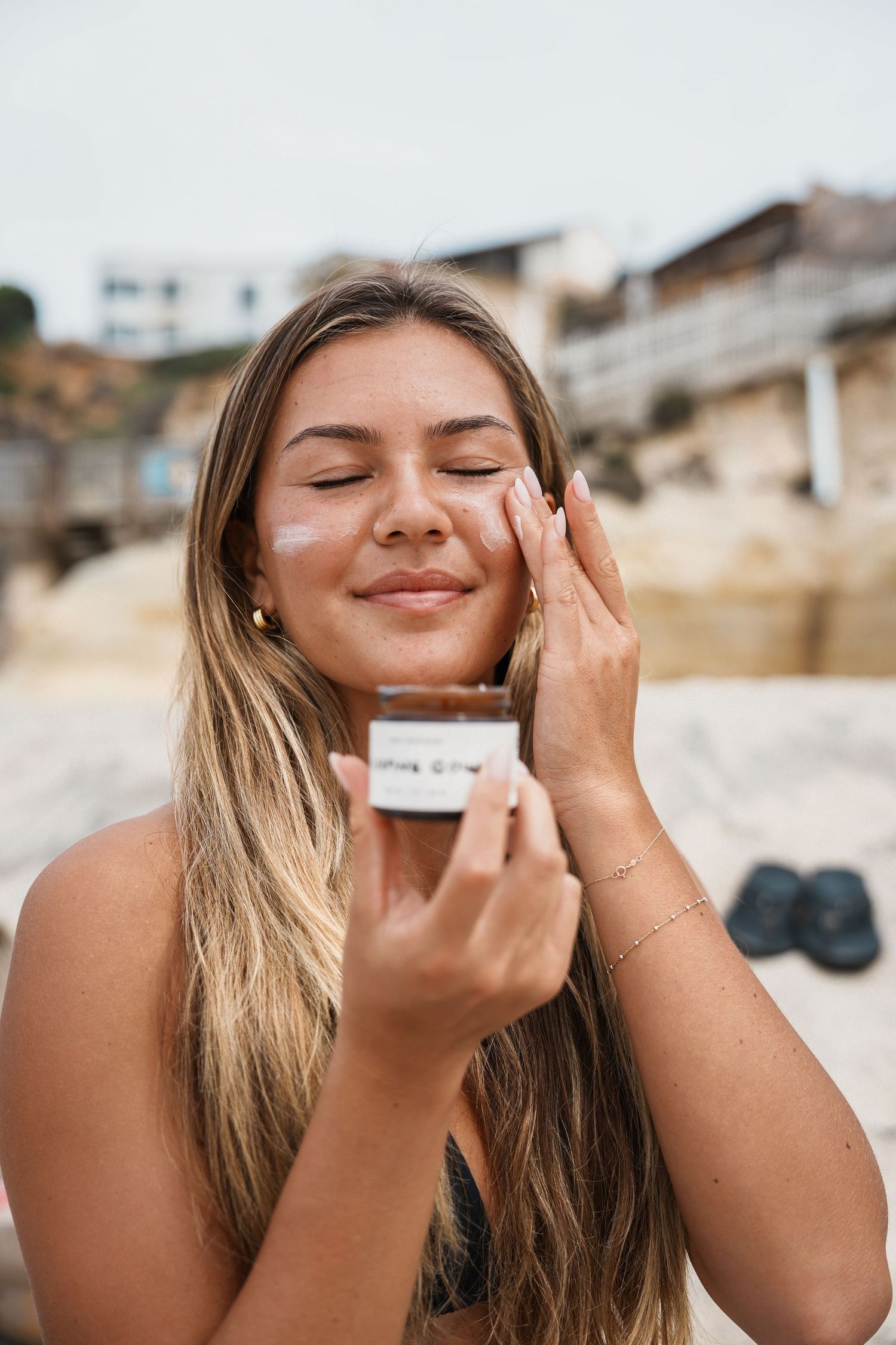 Series of shots showing sunscreen application at the beach.