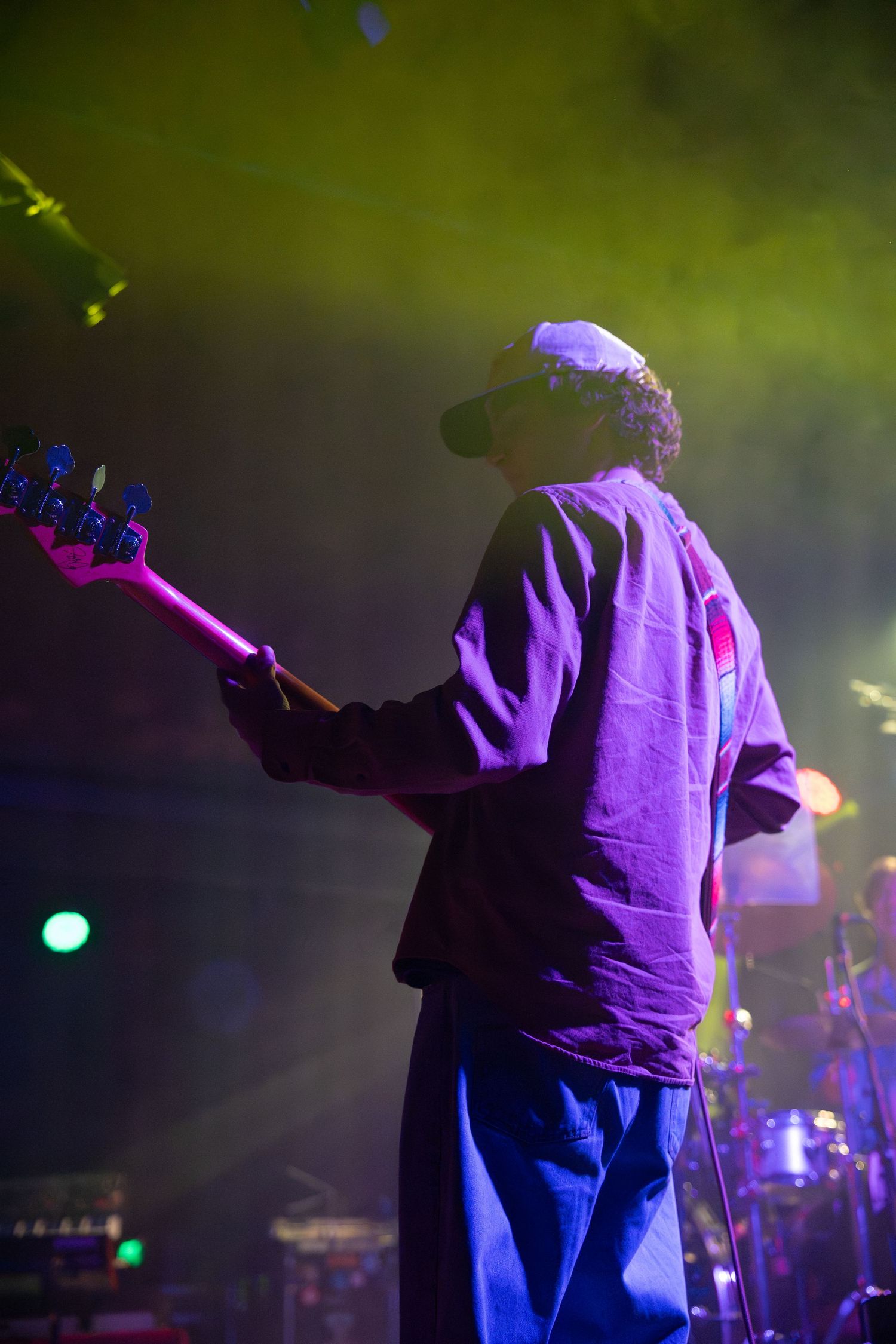 Silhouetted performer in purple lighting on stage during a concert performance.