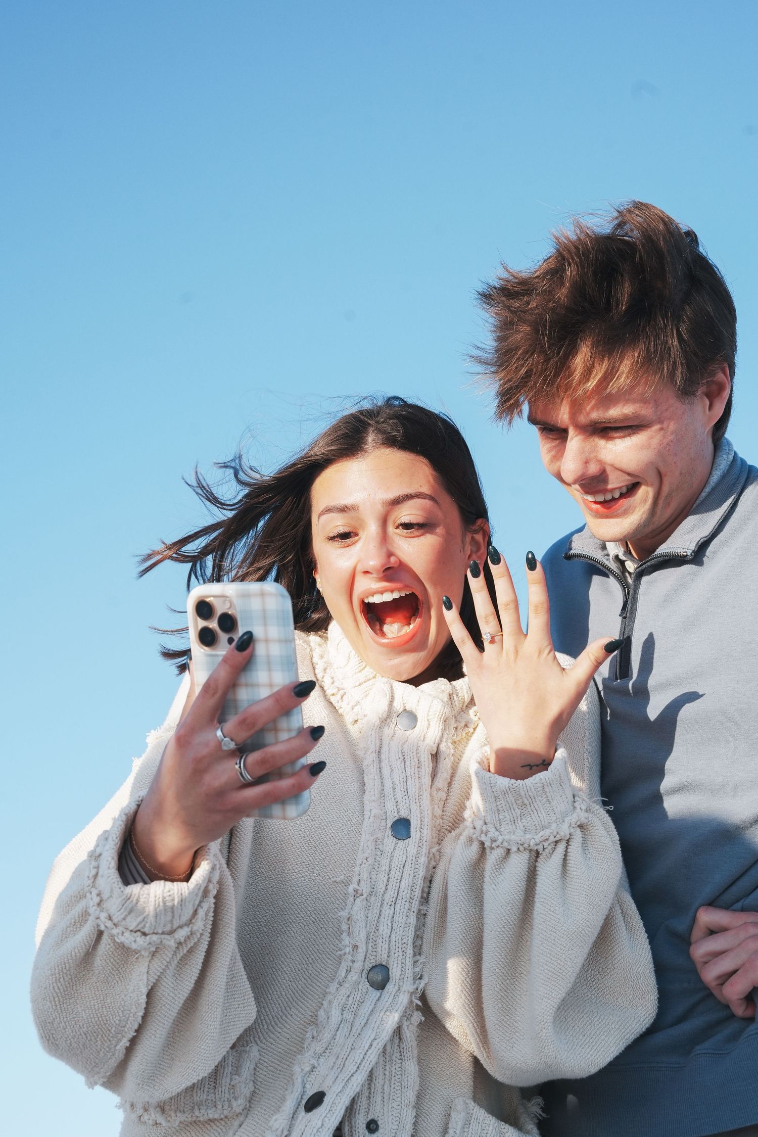 A sequence of photos showing someone reacting with excitement while looking at a phone screen against a blue sky.