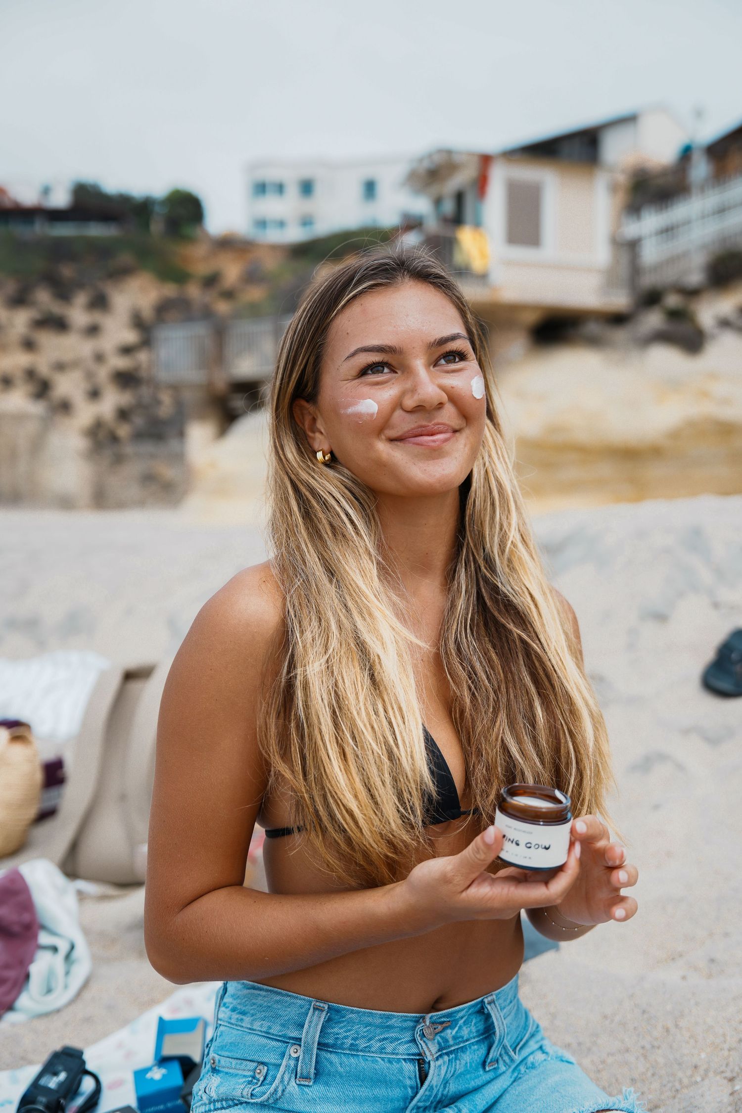Woman in denim shorts enjoying a sunny day at the beach.