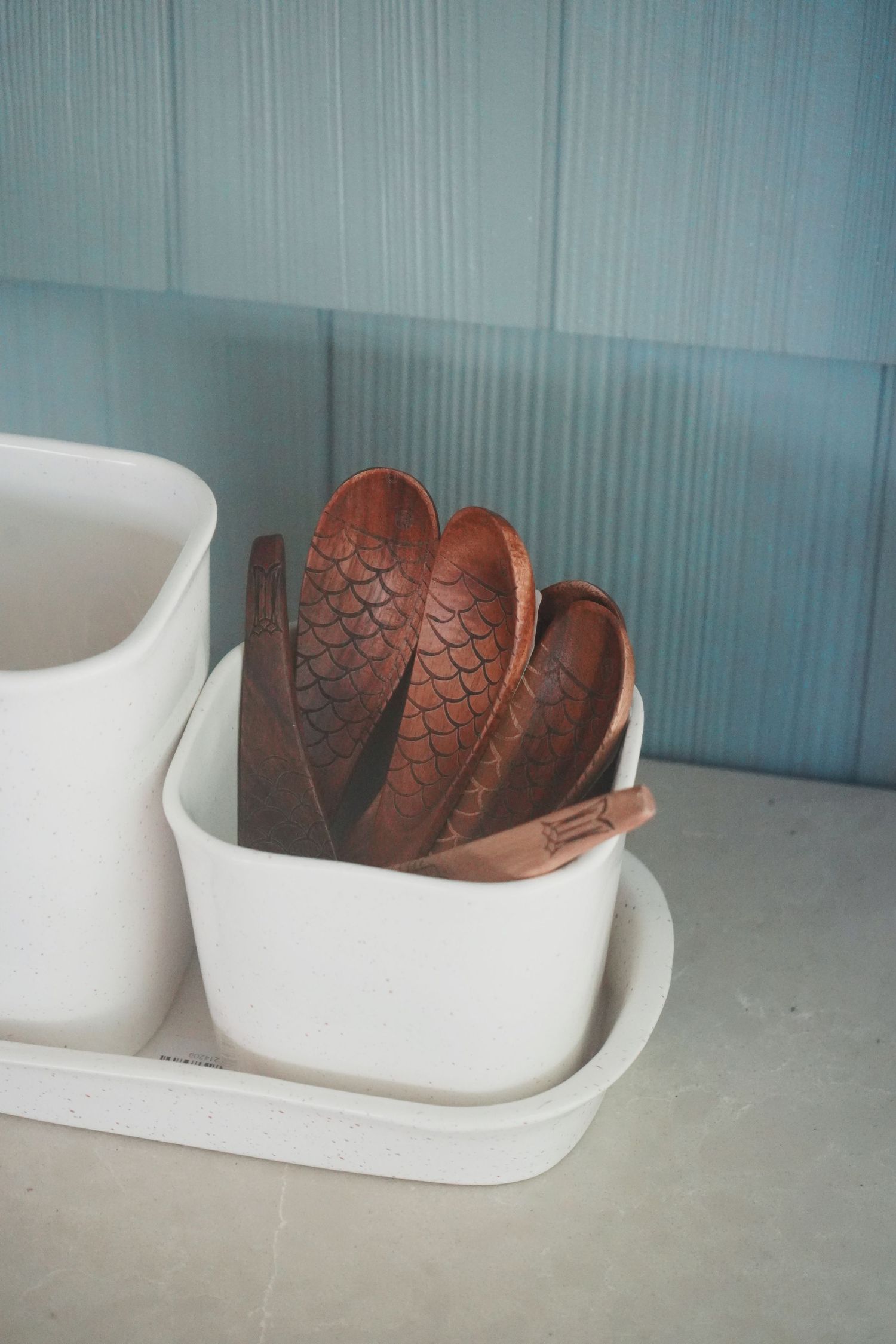 Brown vintage baseball glove rests in a white ceramic bowl against a blue-tinted background.