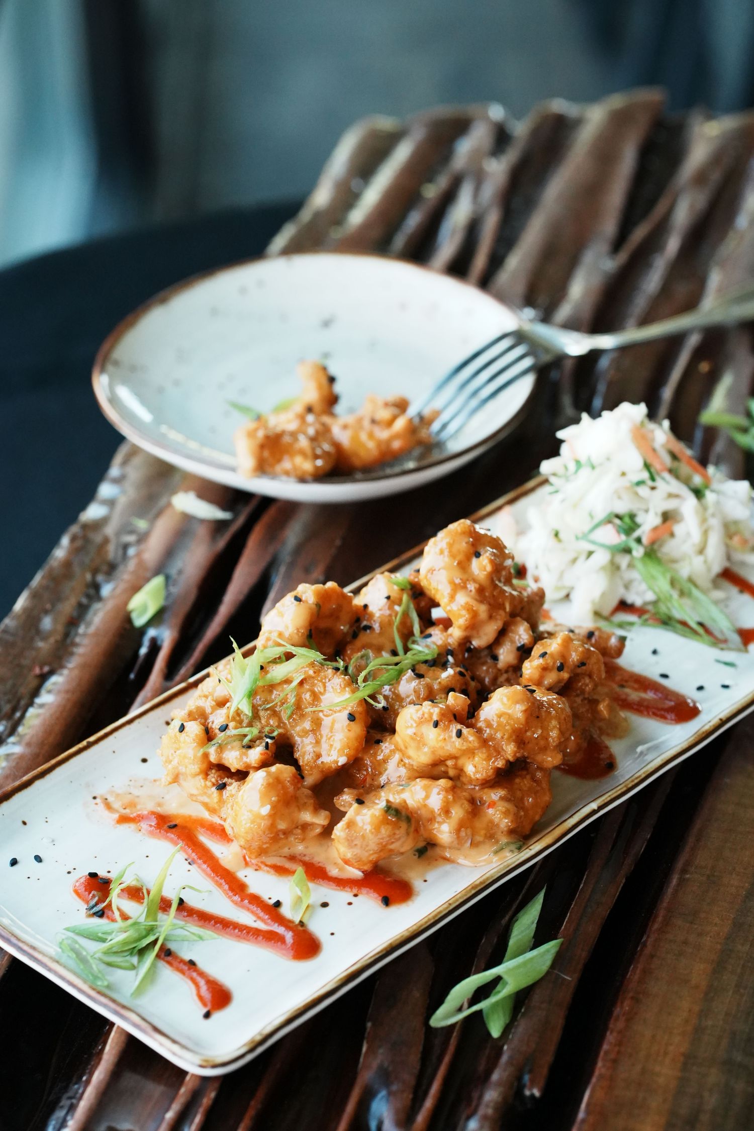 Crispy breaded chicken served with white rice and red peppers on a rectangular white plate.
