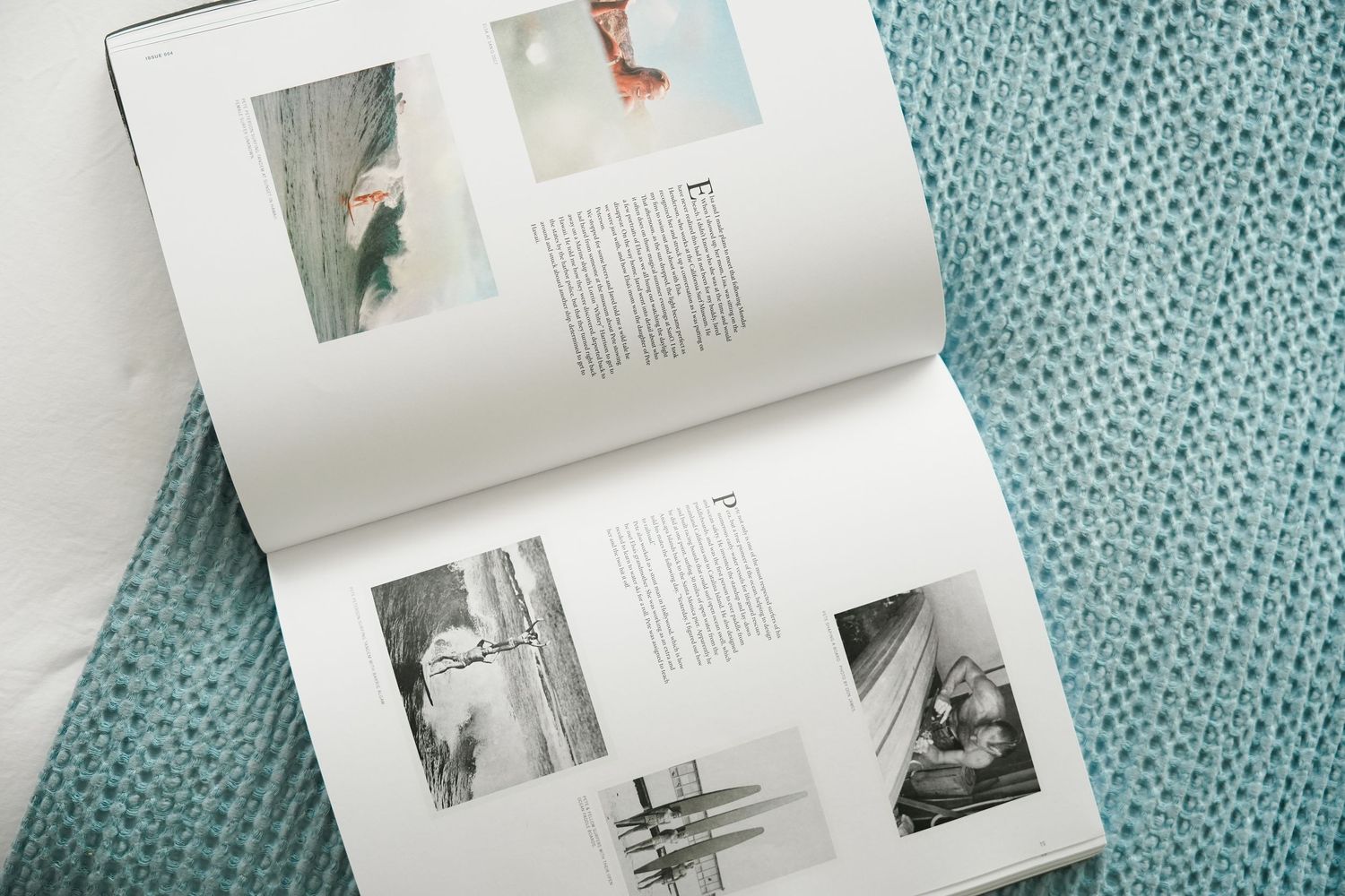 A collection of photo album pages with black and white photographs spread out on a turquoise textured surface.