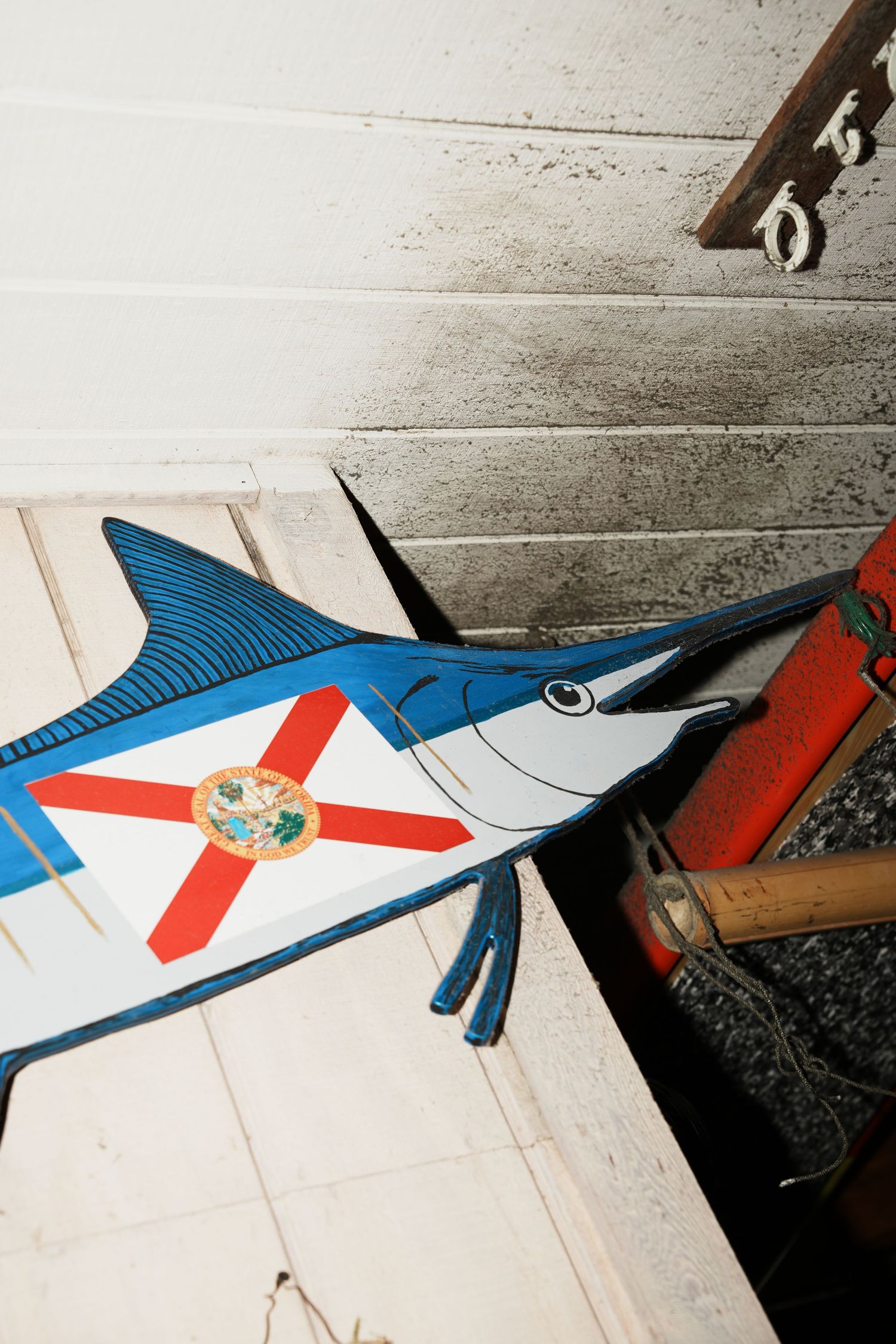 A decorative blue marlin fish cutout mounted on a white wall with a Florida state flag design.