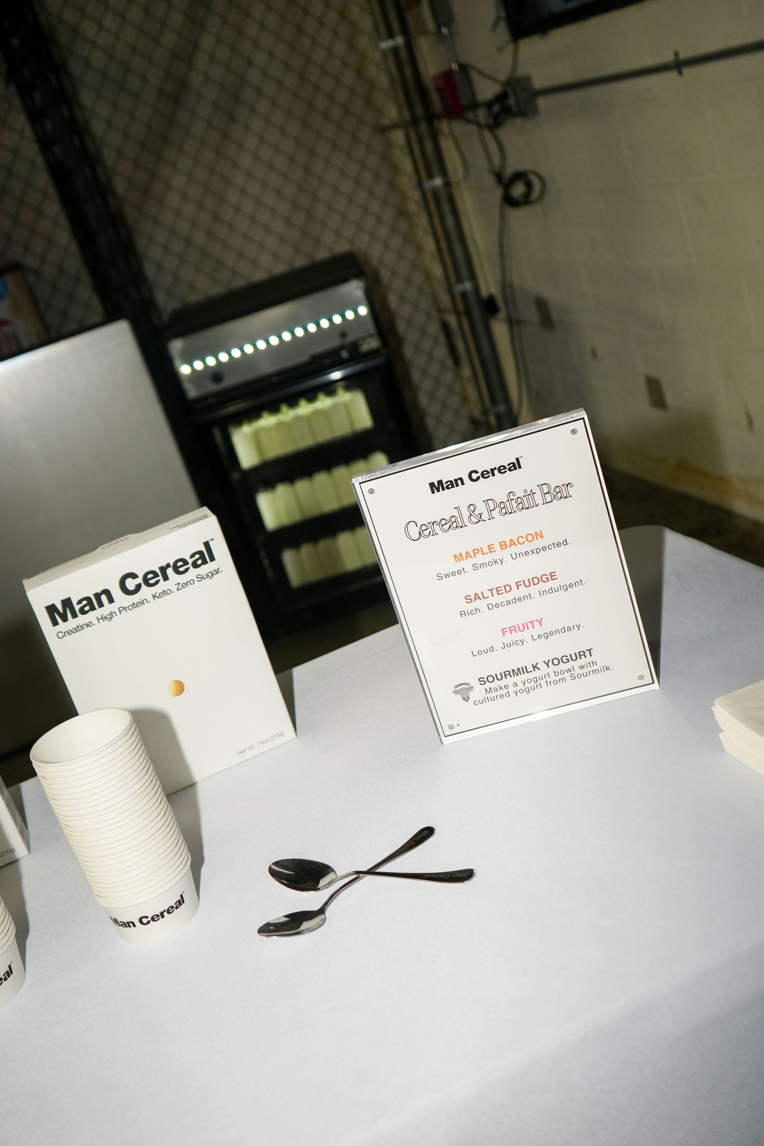 A series of white cylindrical objects displayed on a white surface with business cards and a spoon.
