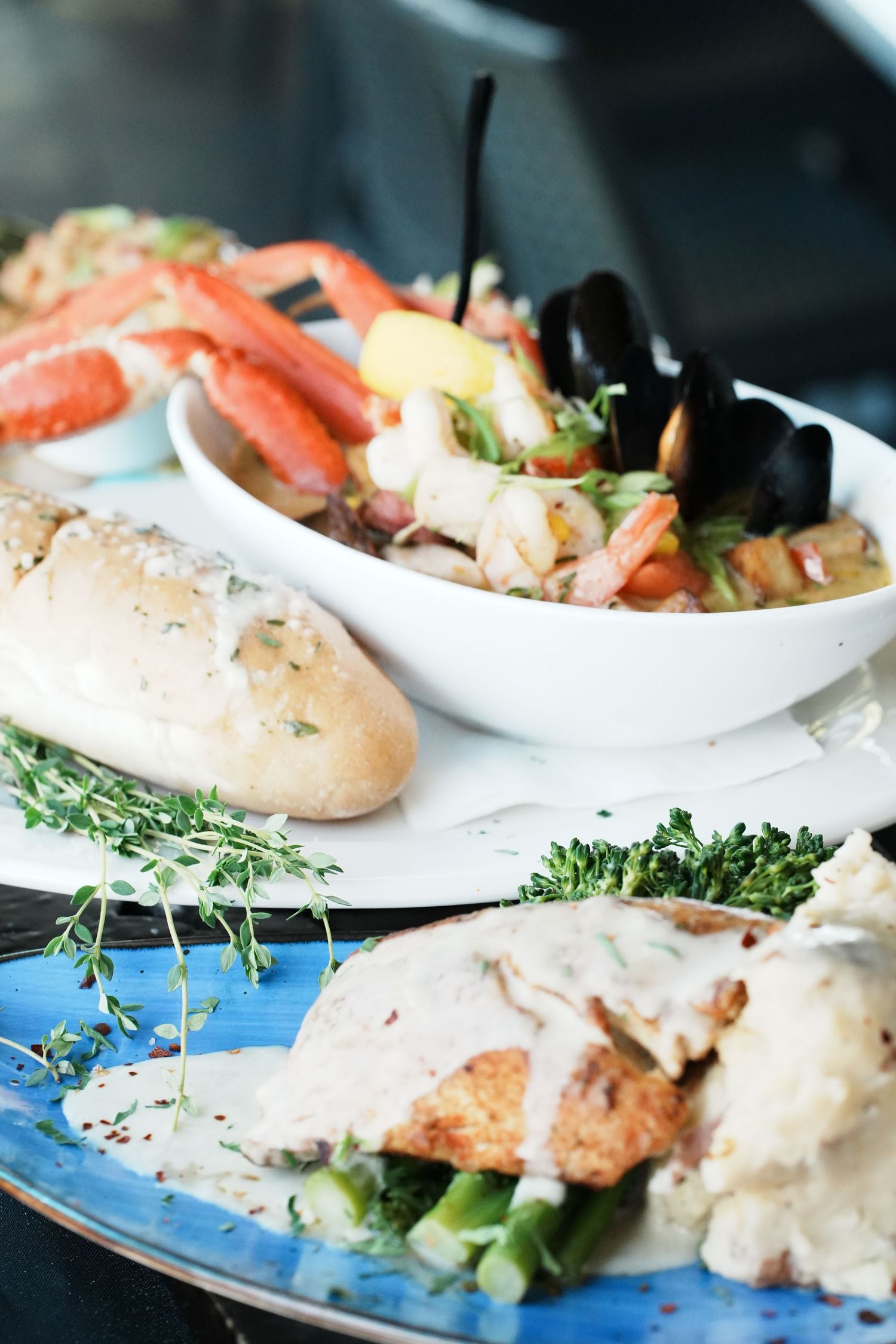 Elegant seafood platter featuring crab legs and shellfish served with fresh bread and herbs.