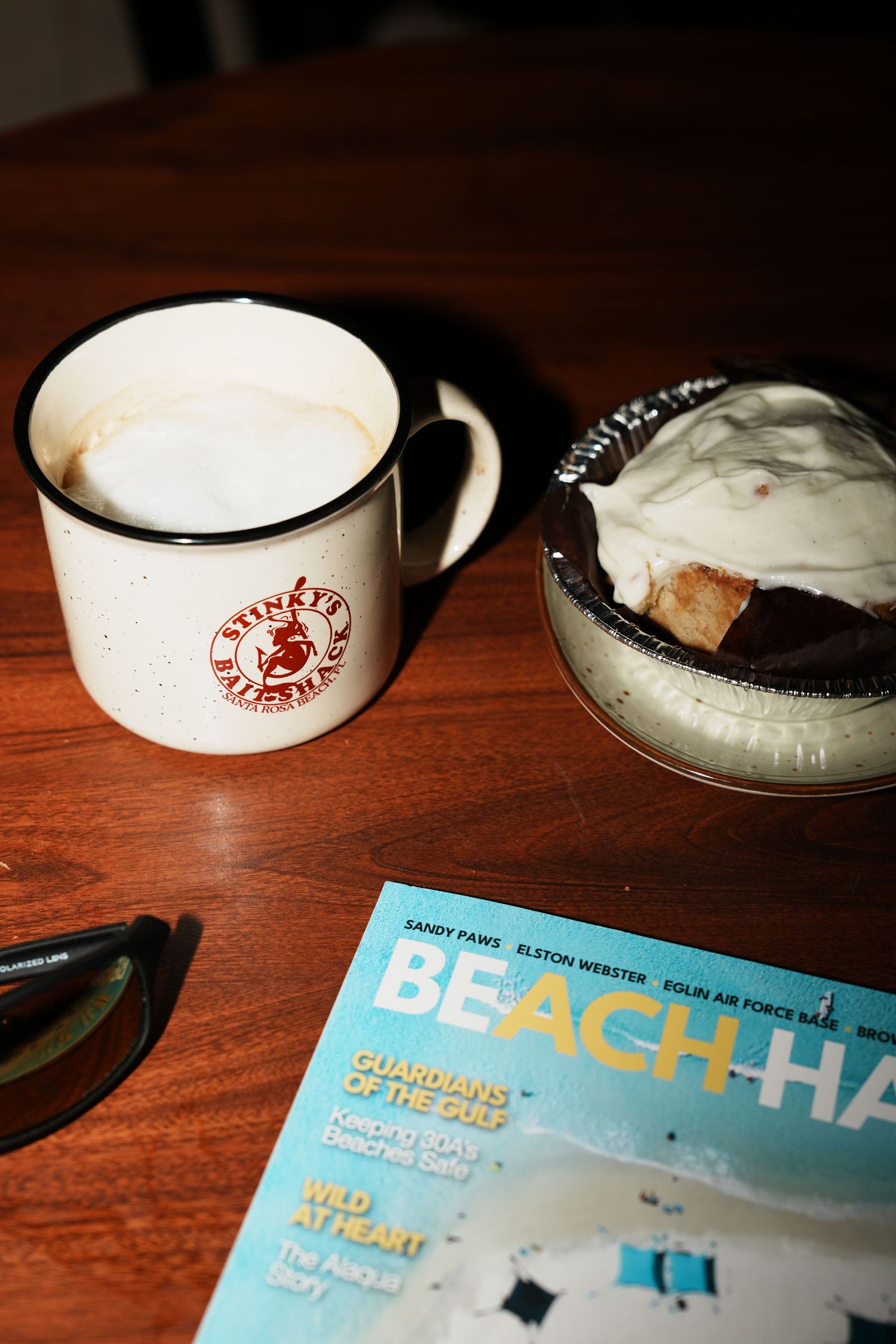 White coffee cups and blue event program materials arranged on a wooden table.